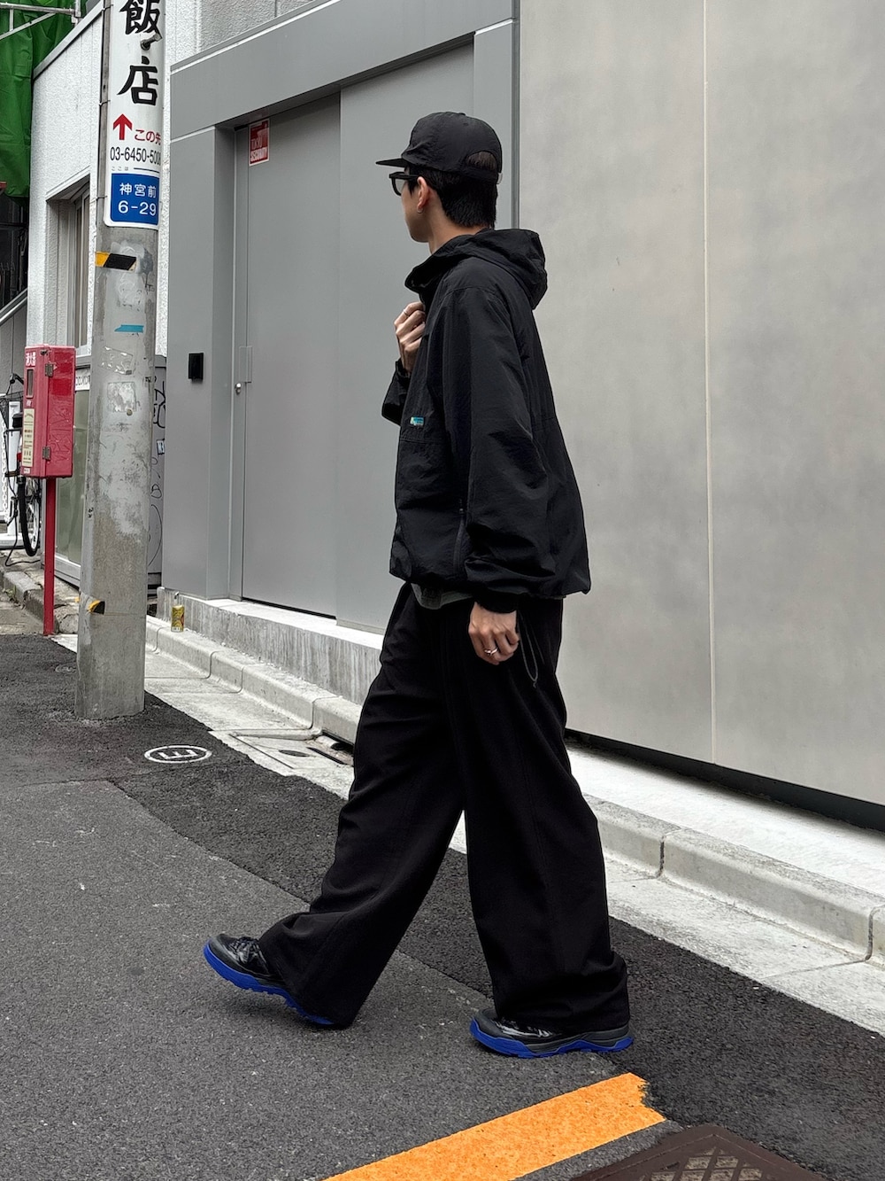 ブラック系のマウンテンパーカー、ブラック系のスラックス、ブラック系のキャップを着用したメンズの夏コーディネートの2枚目の写真