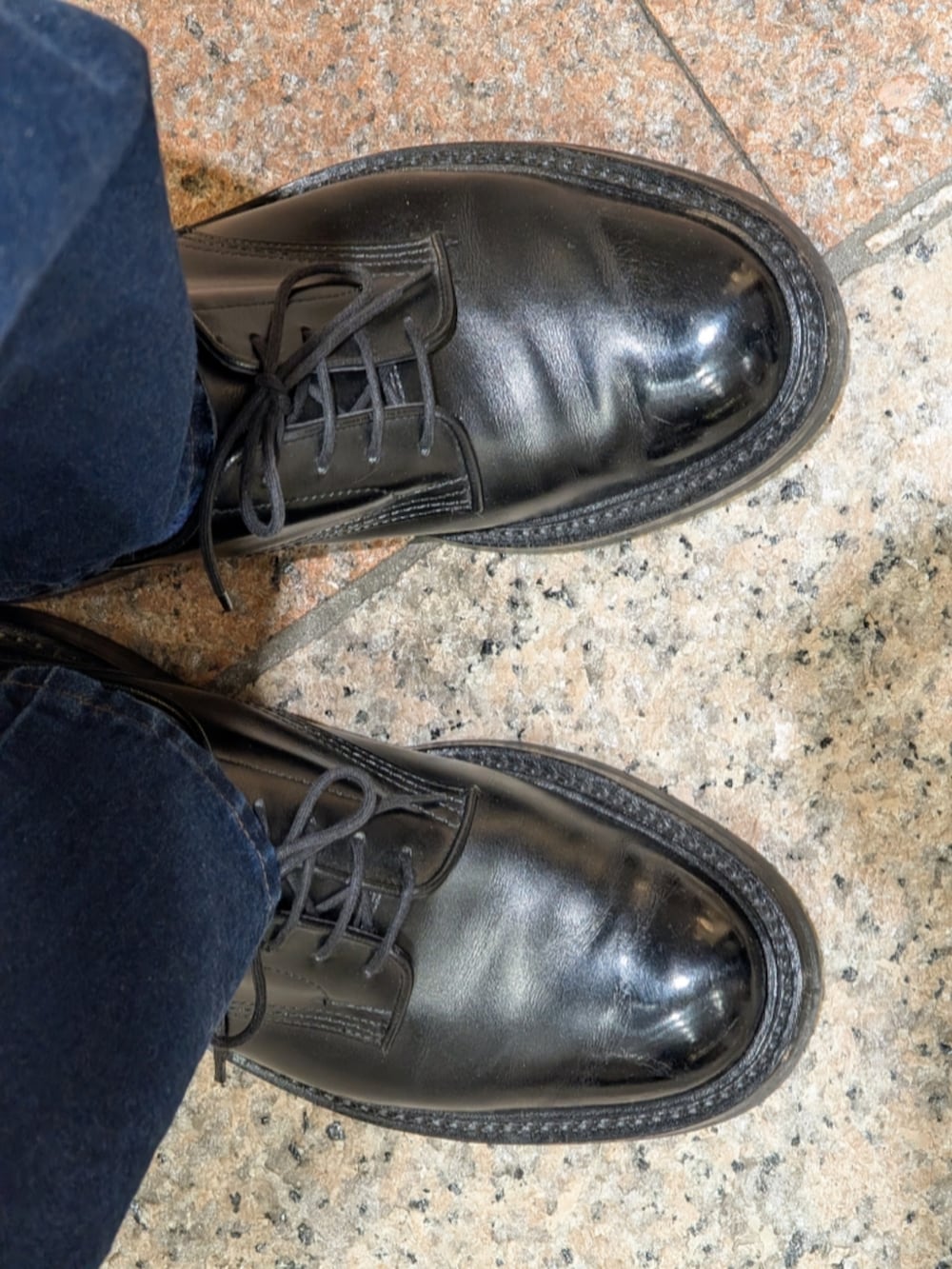 ブラック系のドレスシューズ、ブルー系のデニムパンツ、グリーン系のカバーオールを着用したメンズの冬コーディネートの3枚目の写真