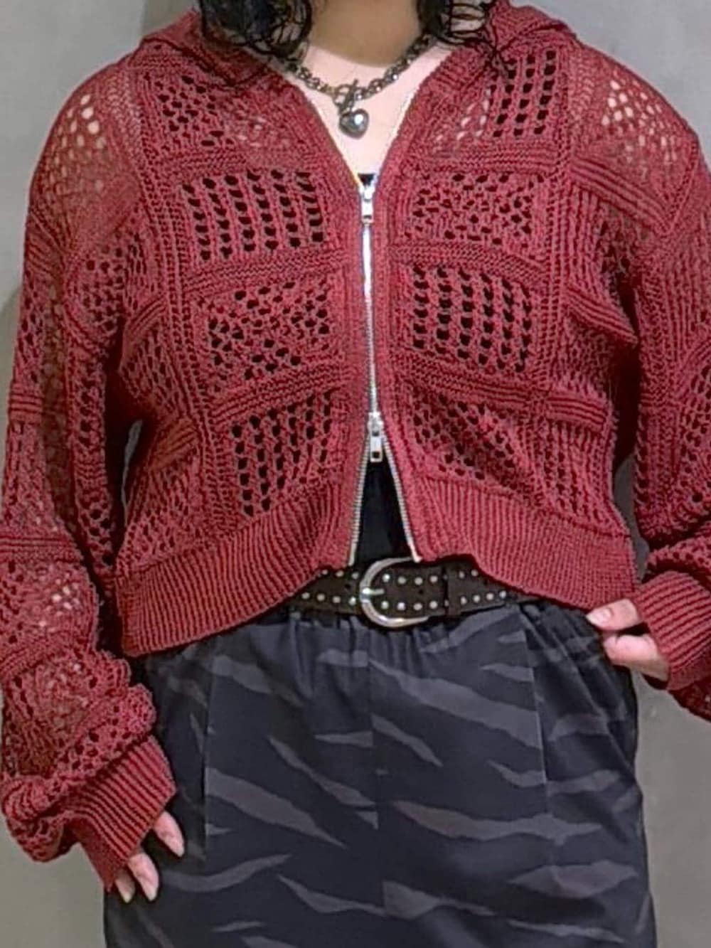 ブラック系のスニーカー、ブラック系のタンクトップ、レッド系のパーカーを着用したレディースの春コーディネートの5枚目の写真