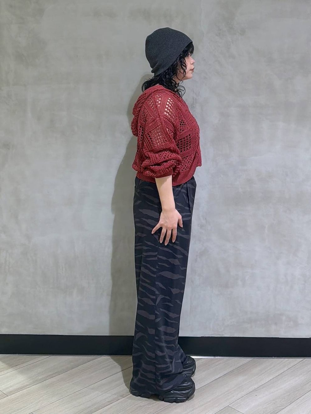 ブラック系のスニーカー、ブラック系のタンクトップ、レッド系のパーカーを着用したレディースの春コーディネートの4枚目の写真