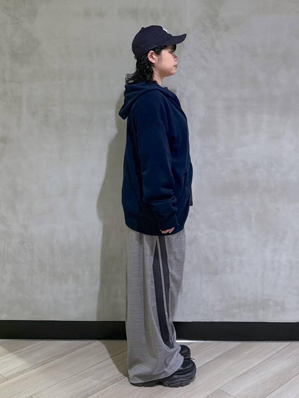 ブラック系のスニーカー、ブルー系のパーカー、ブラック系のTシャツ/カットソーを着用したレディースの冬コーディネートの4枚目の写真