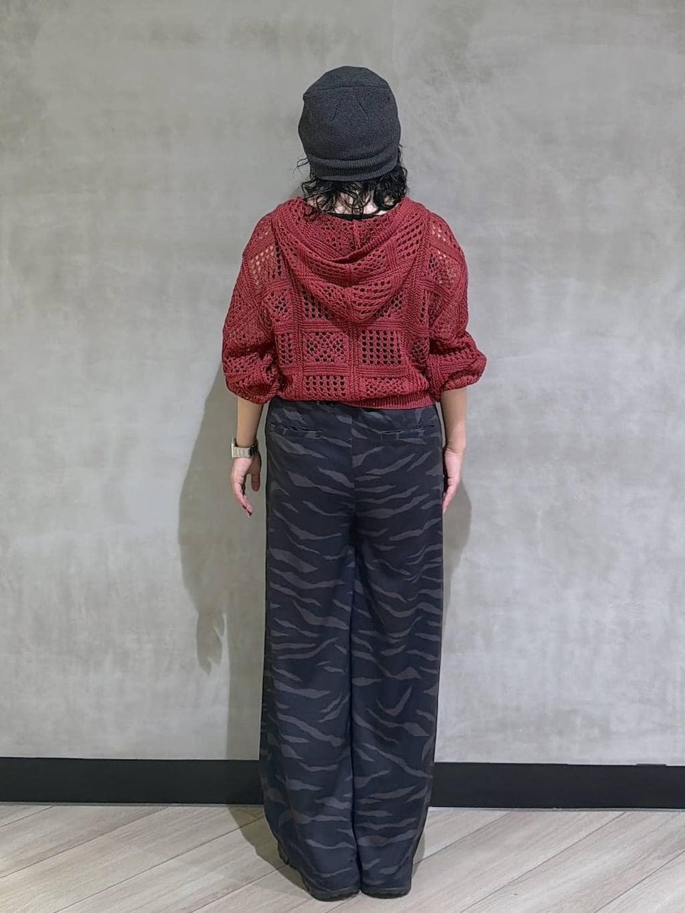 ブラック系のスニーカー、ブラック系のタンクトップ、レッド系のパーカーを着用したレディースの春コーディネートの3枚目の写真