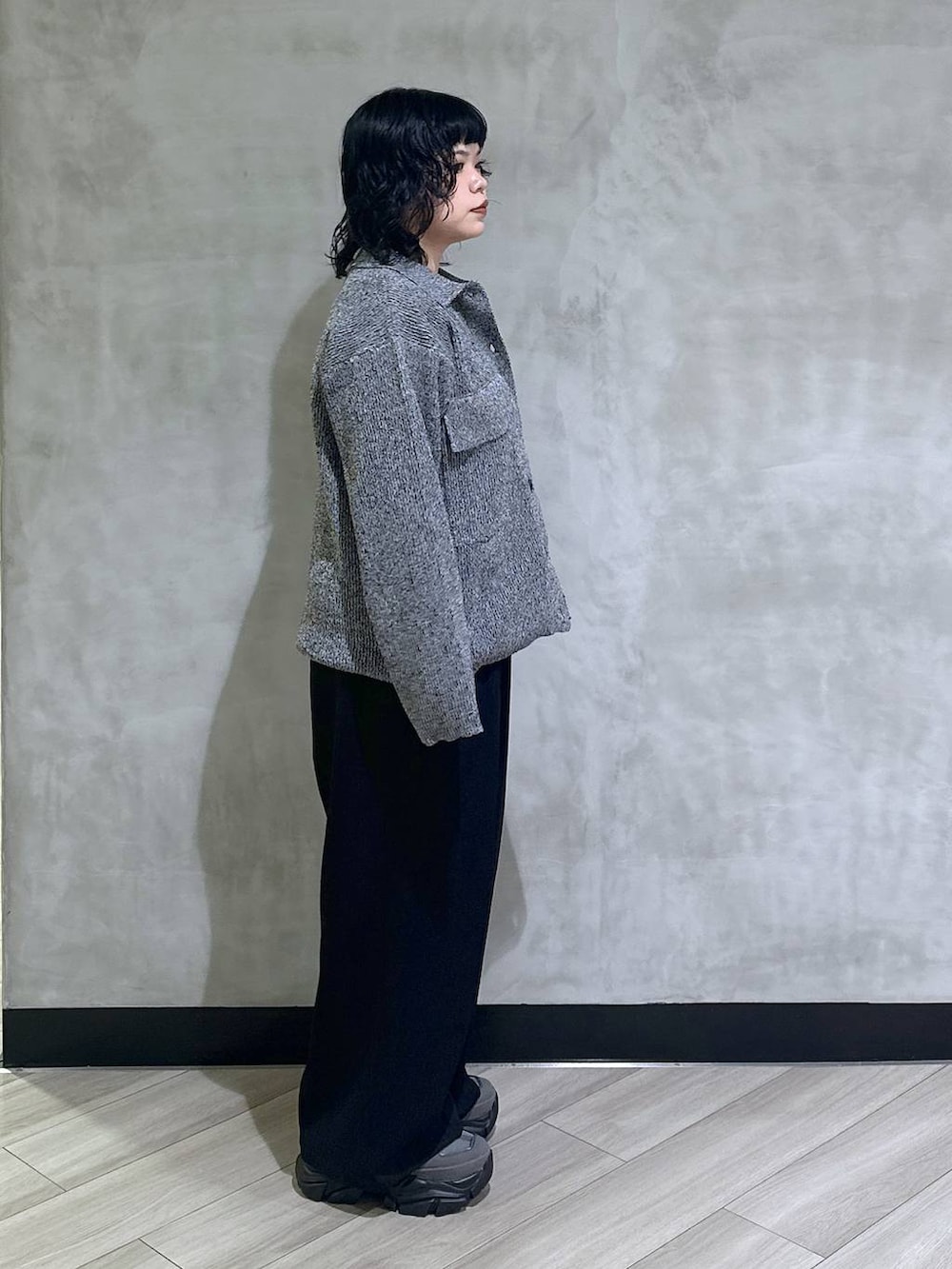 グレー系のスニーカー、ブラック系のスラックス、ブラック系のブルゾンを着用したレディースの秋コーディネートの2枚目の写真