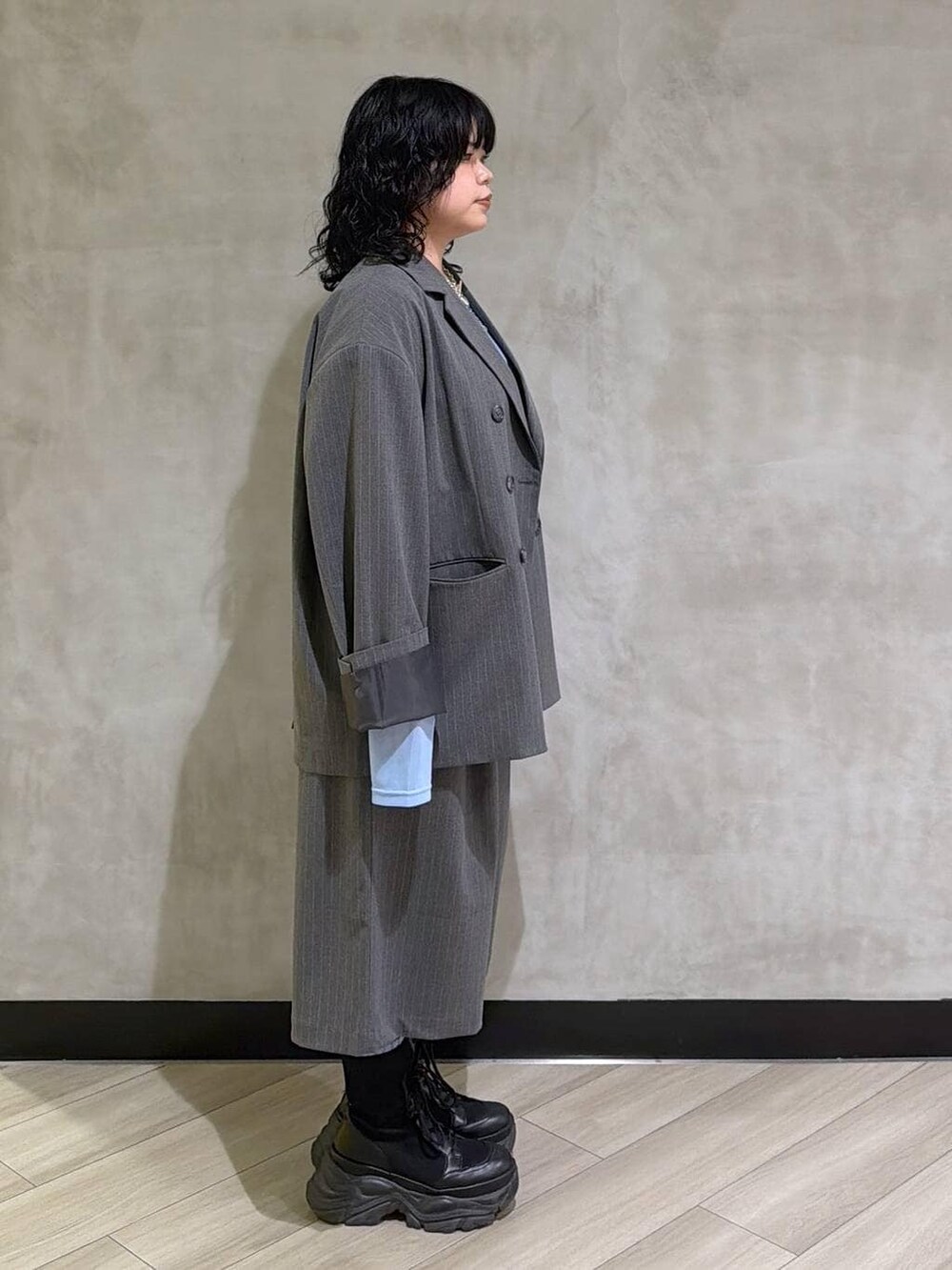 ブラック系のブーツ、ブラック系のその他トップス、グレー系のテーラードジャケットを着用したレディースの春コーディネートの2枚目の写真