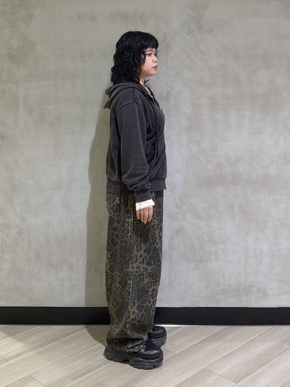 ブラック系のブーツ、ホワイト系のTシャツ/カットソー、ブラック系のパーカーを着用したレディースの冬コーディネートの2枚目の写真