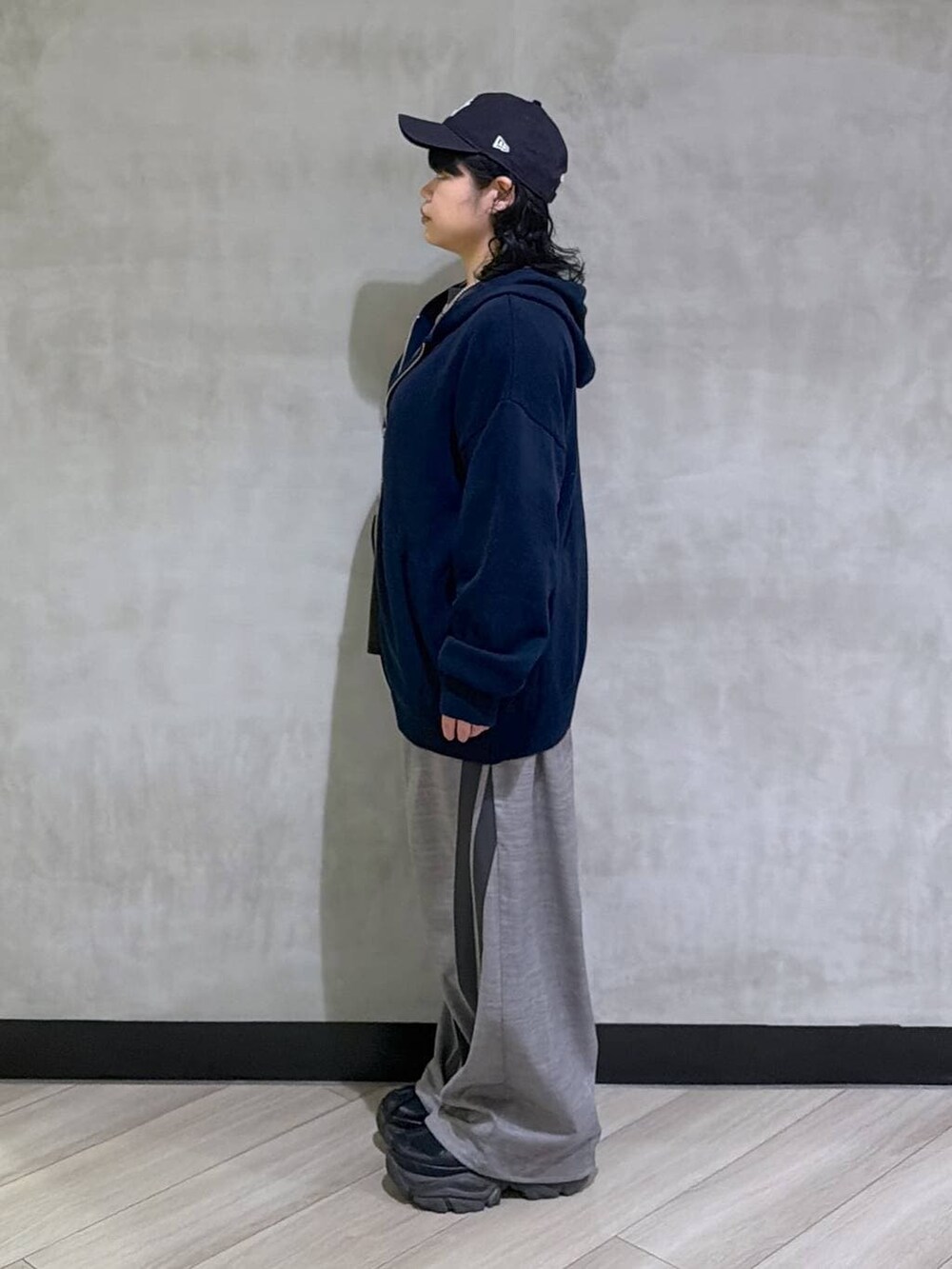 ブラック系のスニーカー、ブルー系のパーカー、ブラック系のTシャツ/カットソーを着用したレディースの冬コーディネートの2枚目の写真