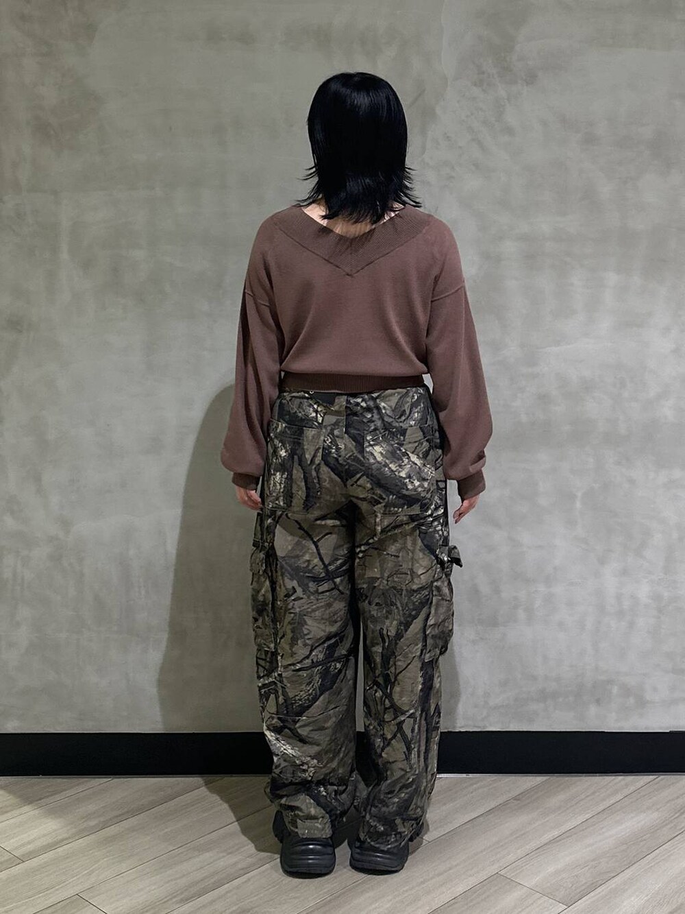 ブラック系のスニーカー、グリーン系のカーゴパンツ、ブラウン系のニット/セーターを着用したレディースの秋コーディネートの3枚目の写真