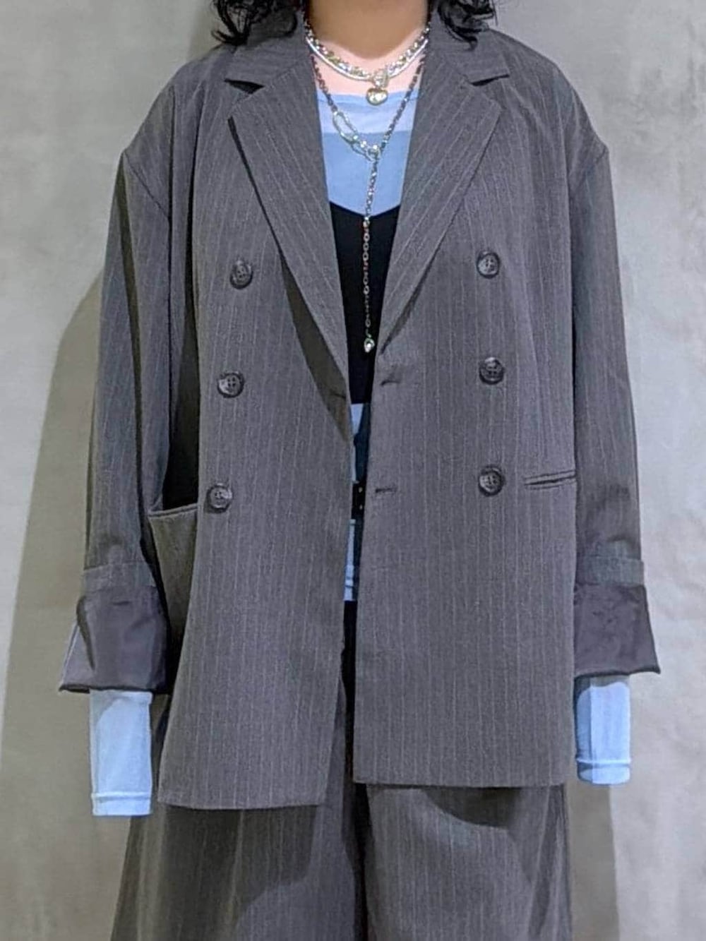 ブラック系のブーツ、ブラック系のその他トップス、グレー系のテーラードジャケットを着用したレディースの春コーディネートの5枚目の写真