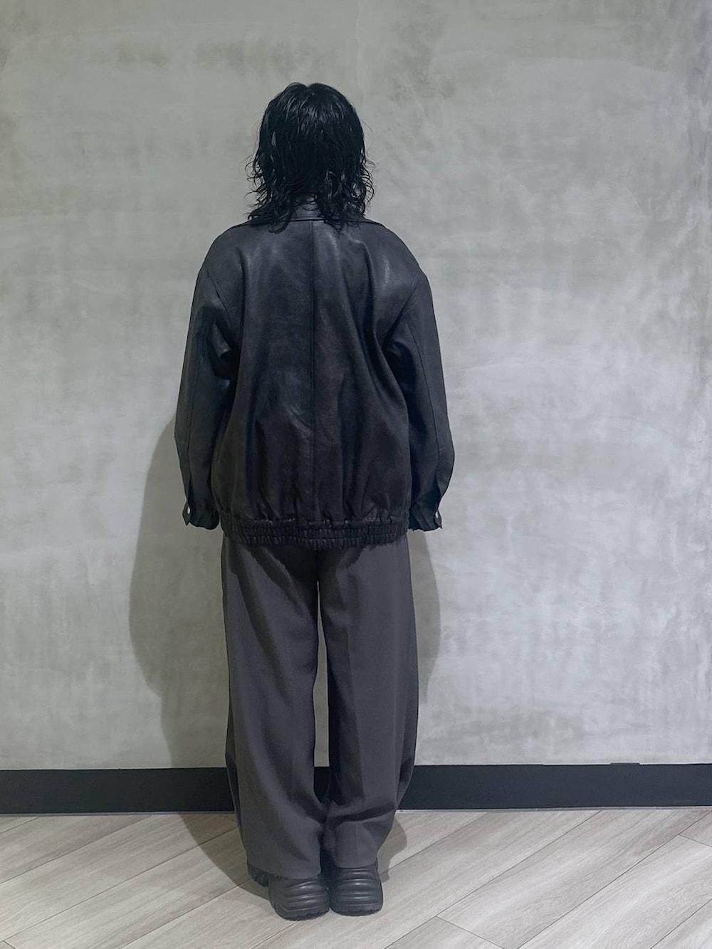 ブラック系のスニーカー、ブラック系のブルゾン、グレー系のスラックスを着用したレディースの秋コーディネートの3枚目の写真