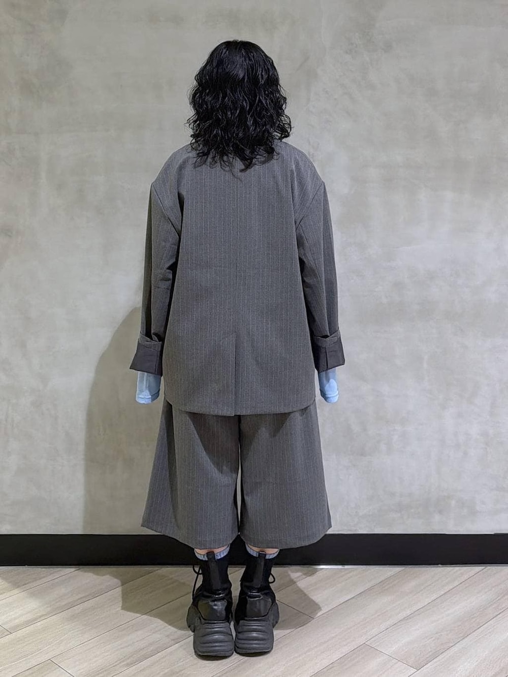 ブラック系のブーツ、ブラック系のその他トップス、グレー系のテーラードジャケットを着用したレディースの春コーディネートの3枚目の写真