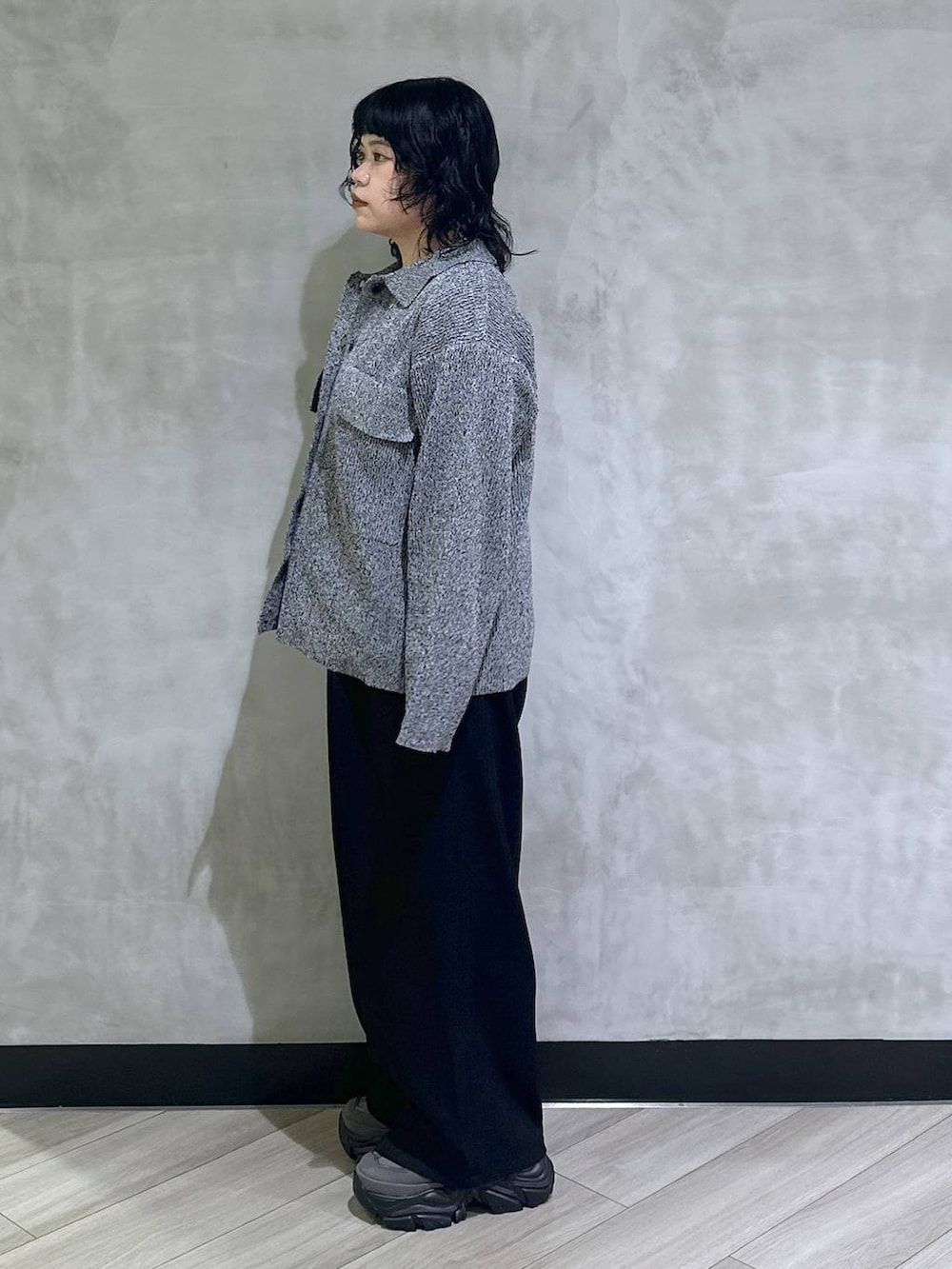 グレー系のスニーカー、ブラック系のスラックス、ブラック系のブルゾンを着用したレディースの秋コーディネートの4枚目の写真