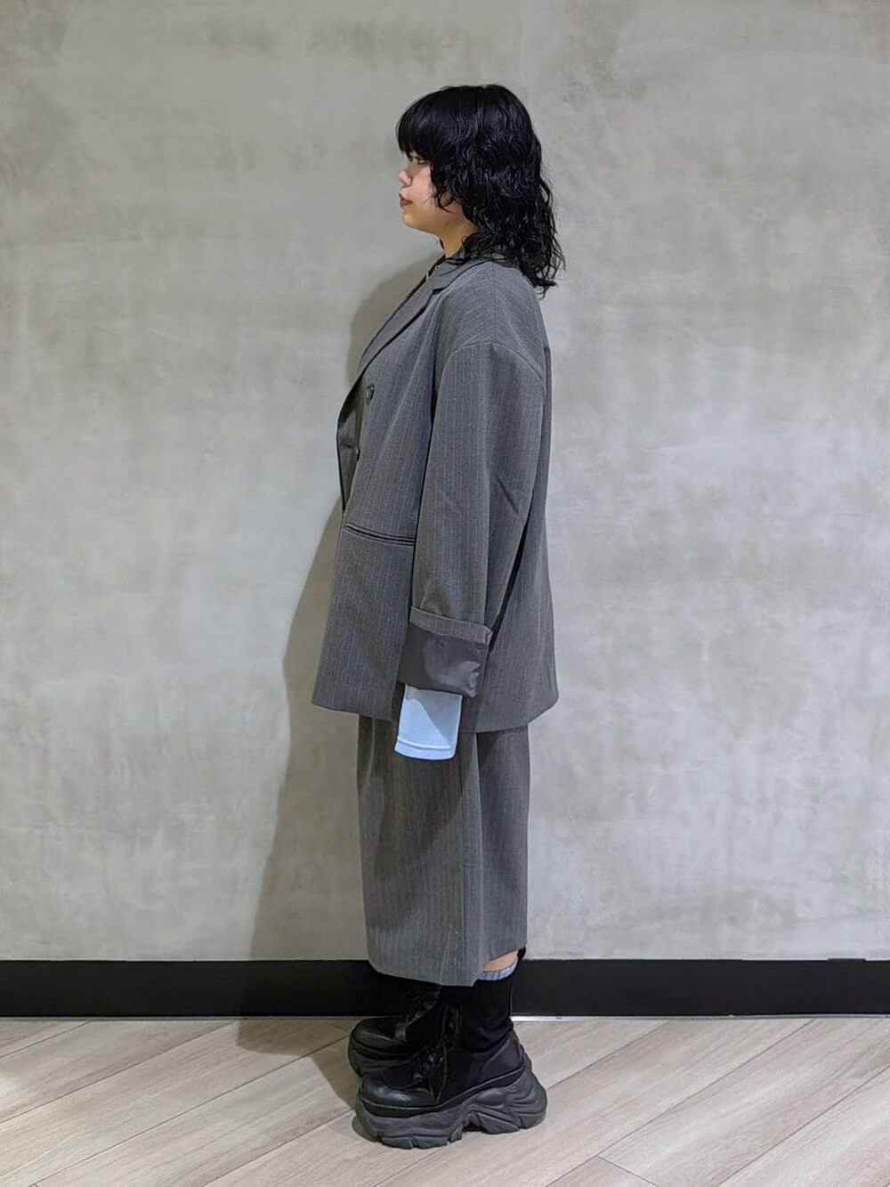 ブラック系のブーツ、ブラック系のその他トップス、グレー系のテーラードジャケットを着用したレディースの春コーディネートの4枚目の写真