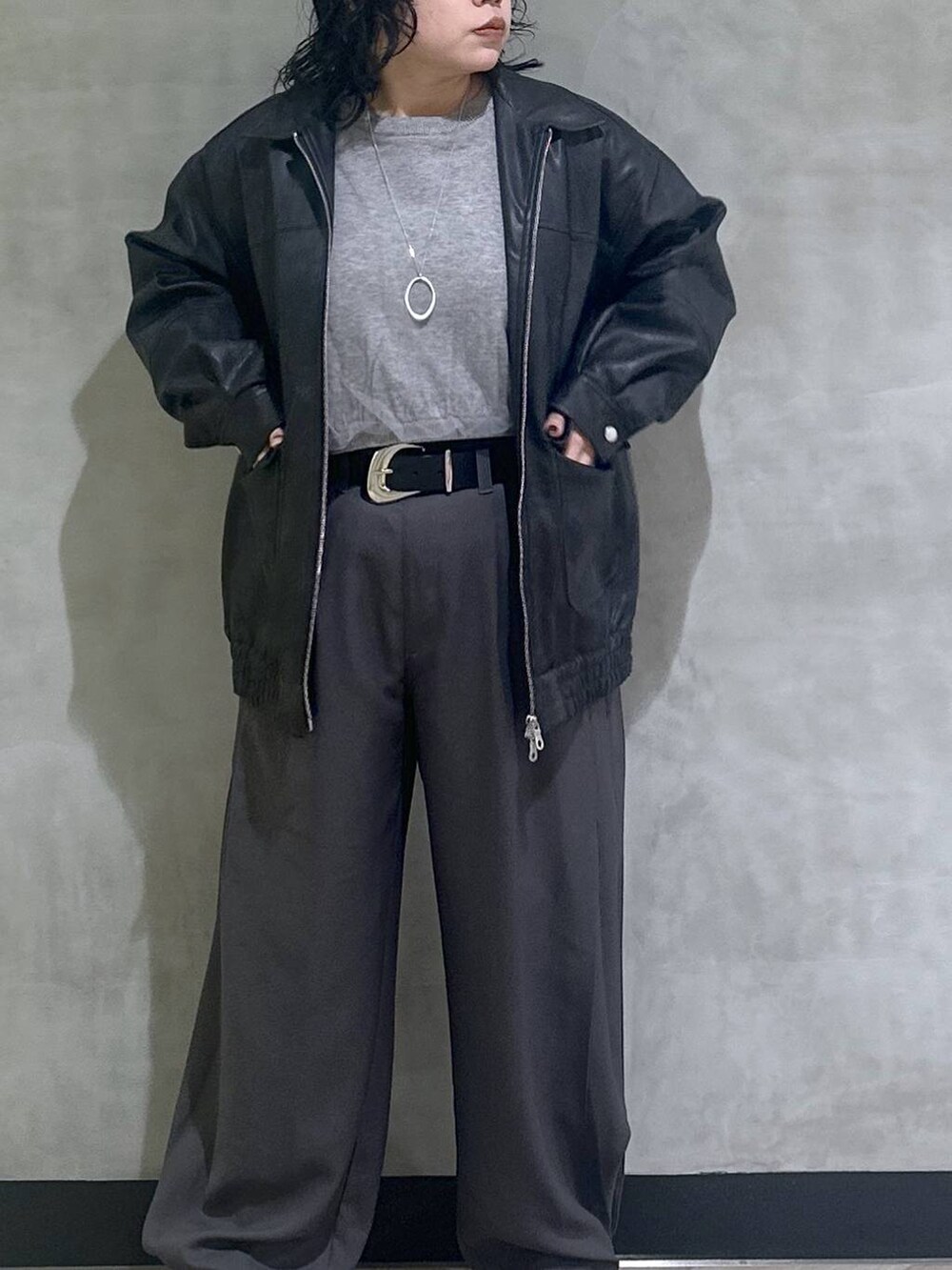 ブラック系のスニーカー、ブラック系のブルゾン、グレー系のスラックスを着用したレディースの秋コーディネートの5枚目の写真