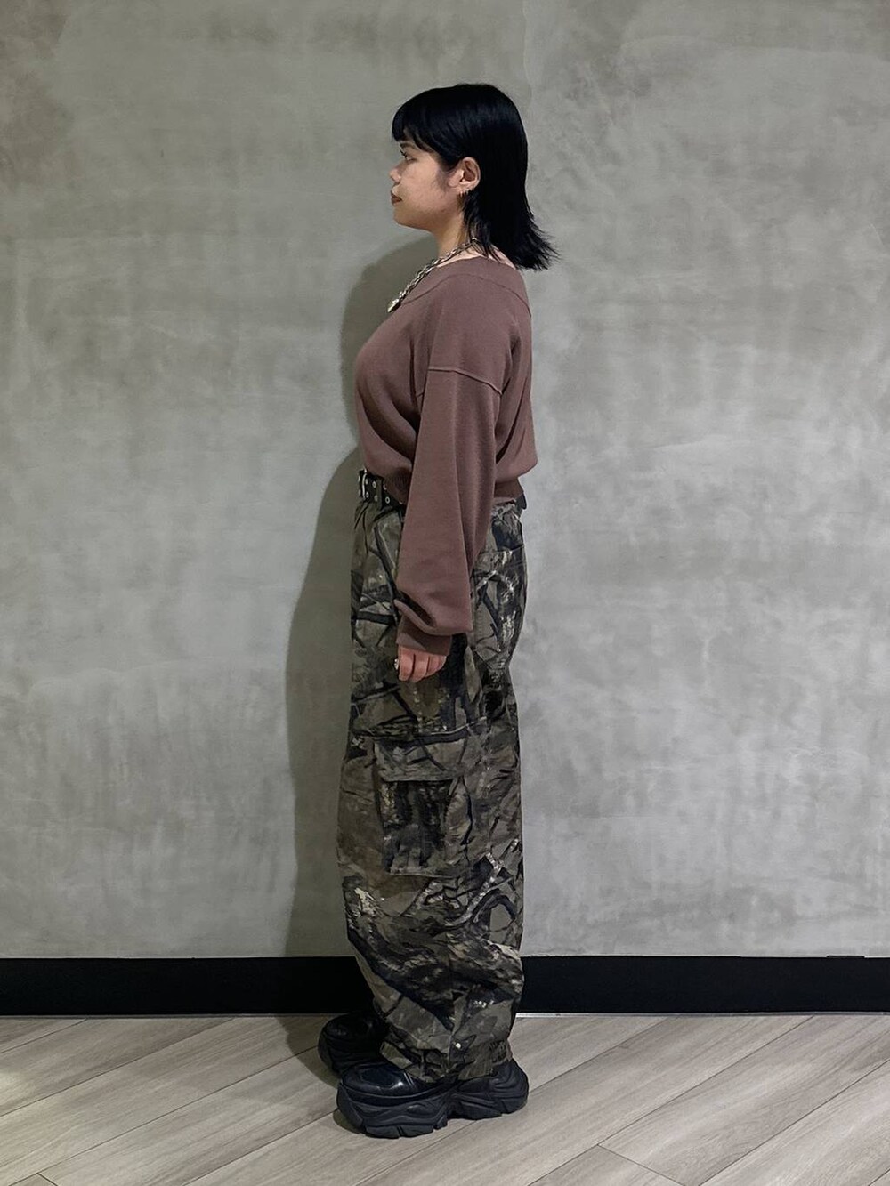 ブラック系のスニーカー、グリーン系のカーゴパンツ、ブラウン系のニット/セーターを着用したレディースの秋コーディネートの4枚目の写真