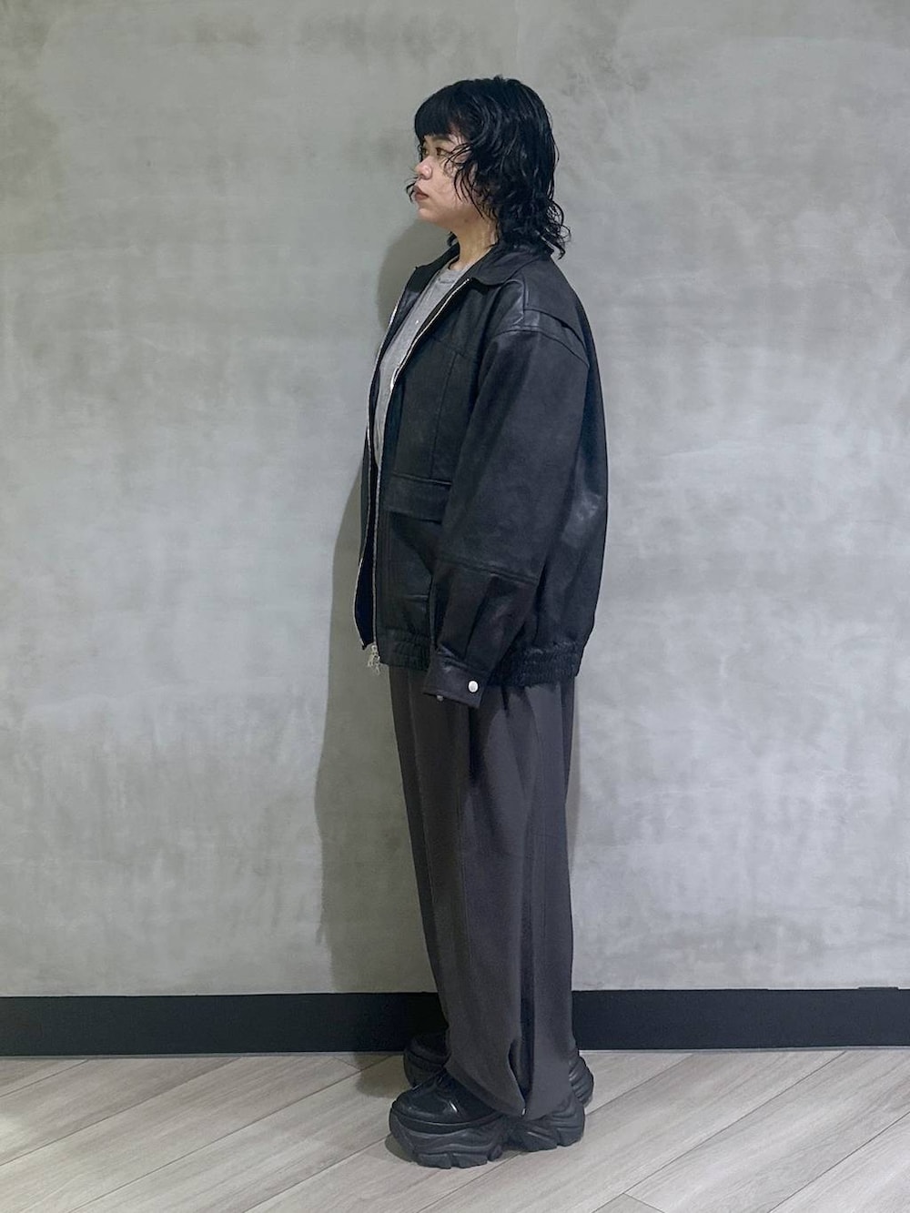 ブラック系のスニーカー、ブラック系のブルゾン、グレー系のスラックスを着用したレディースの秋コーディネートの4枚目の写真