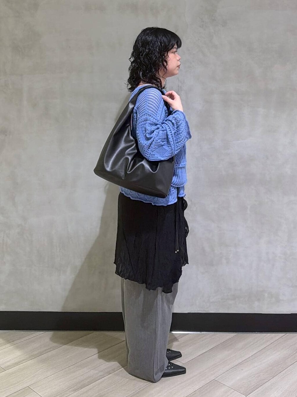 ブラック系のサンダル、ブラック系のトートバッグ、ブラック系のチュニックを着用したレディースの春コーディネートの2枚目の写真