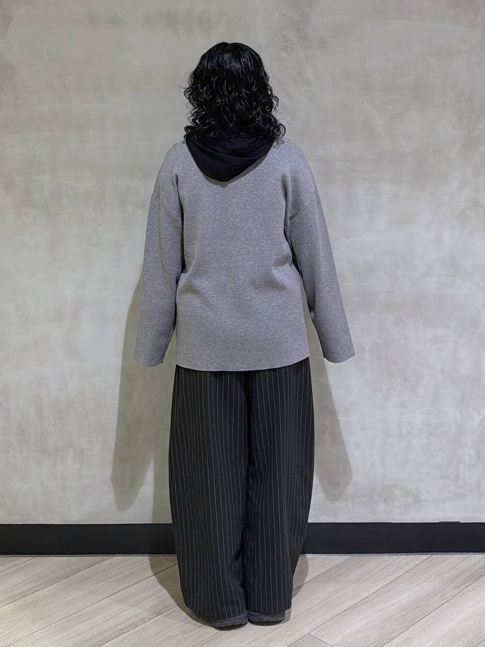 グレー系のスニーカー、ブラック系のスラックス、グレー系のテーラードジャケットを着用したレディースの冬コーディネートの3枚目の写真