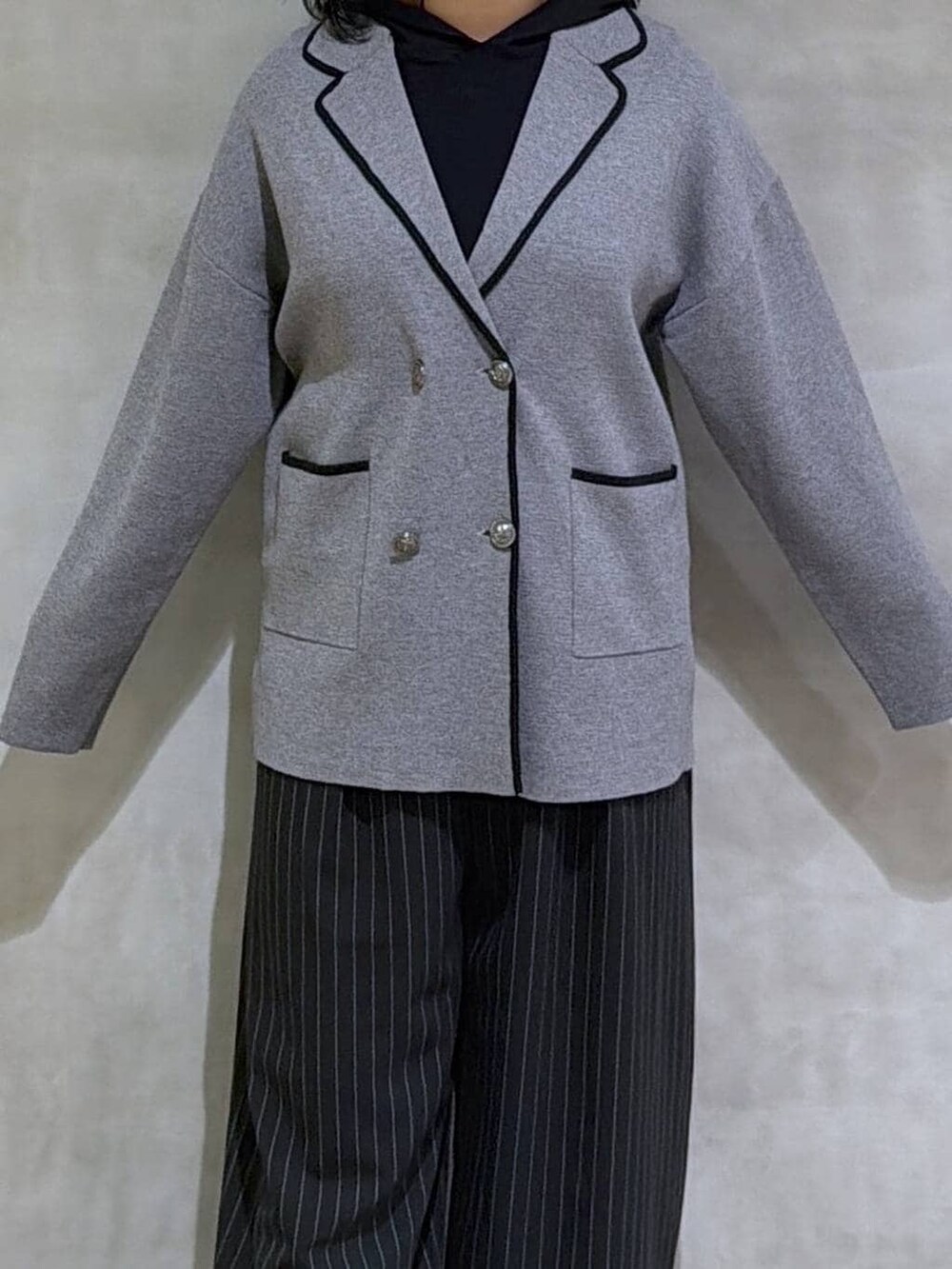 グレー系のスニーカー、ブラック系のスラックス、グレー系のテーラードジャケットを着用したレディースの冬コーディネートの5枚目の写真