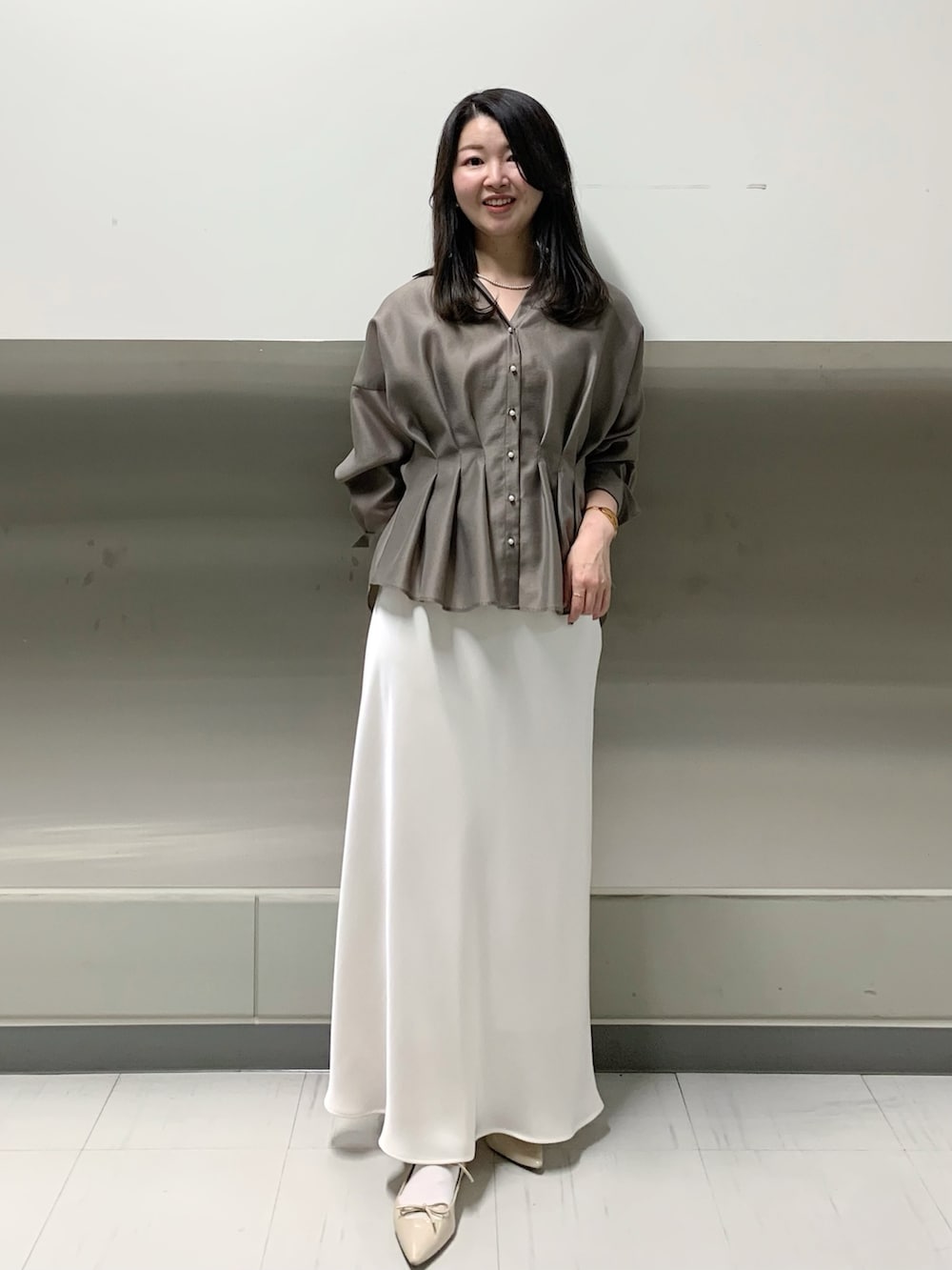 ホワイト系のスカート、グリーン系のシャツ/ブラウスを着用したレディースの春コーディネートの6枚目の写真