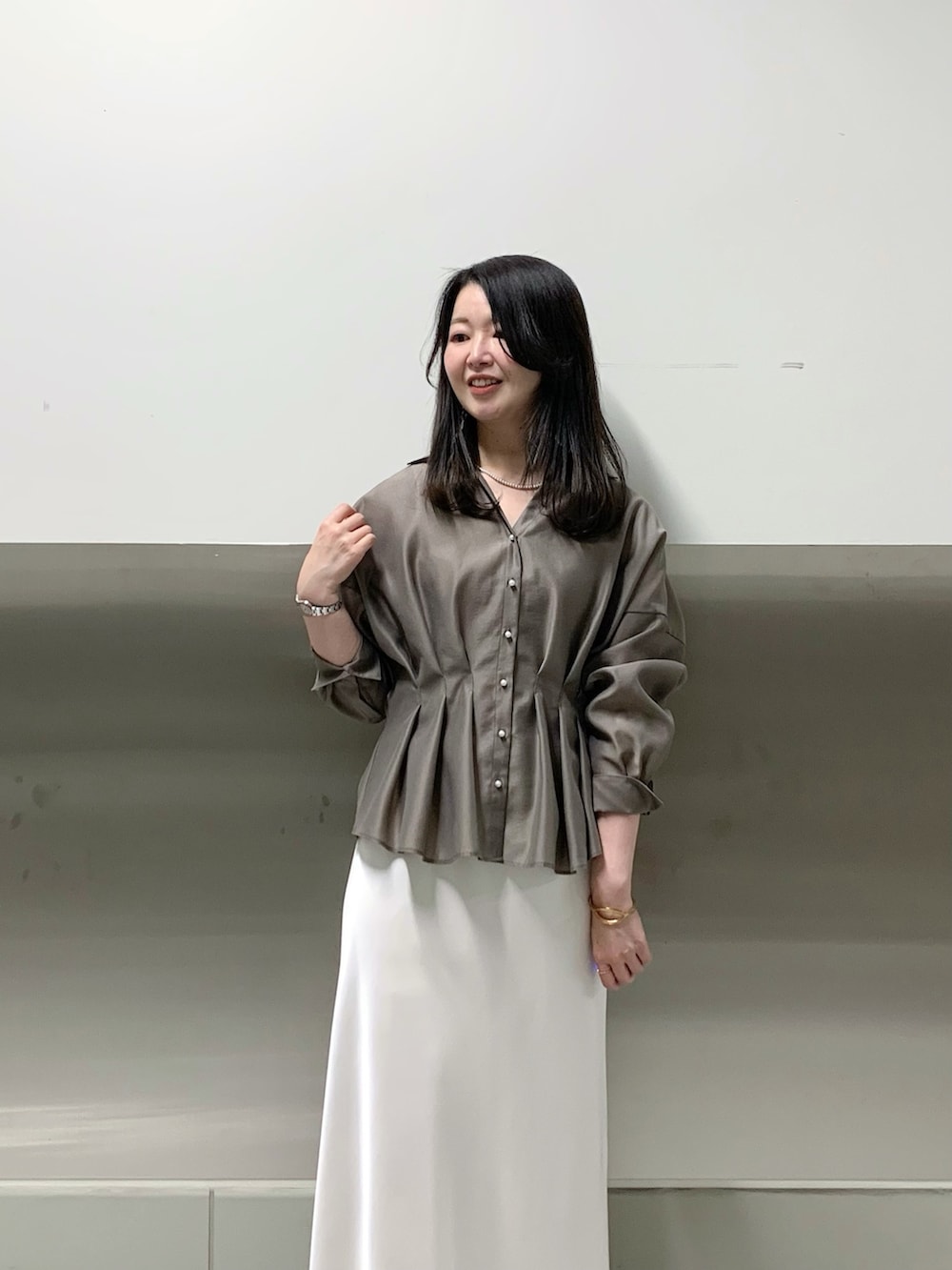 ホワイト系のスカート、グリーン系のシャツ/ブラウスを着用したレディースの春コーディネートの4枚目の写真