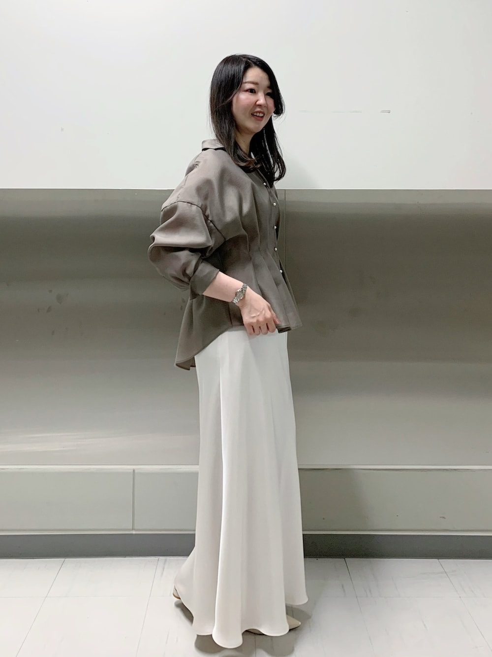 ホワイト系のスカート、グリーン系のシャツ/ブラウスを着用したレディースの春コーディネートの2枚目の写真