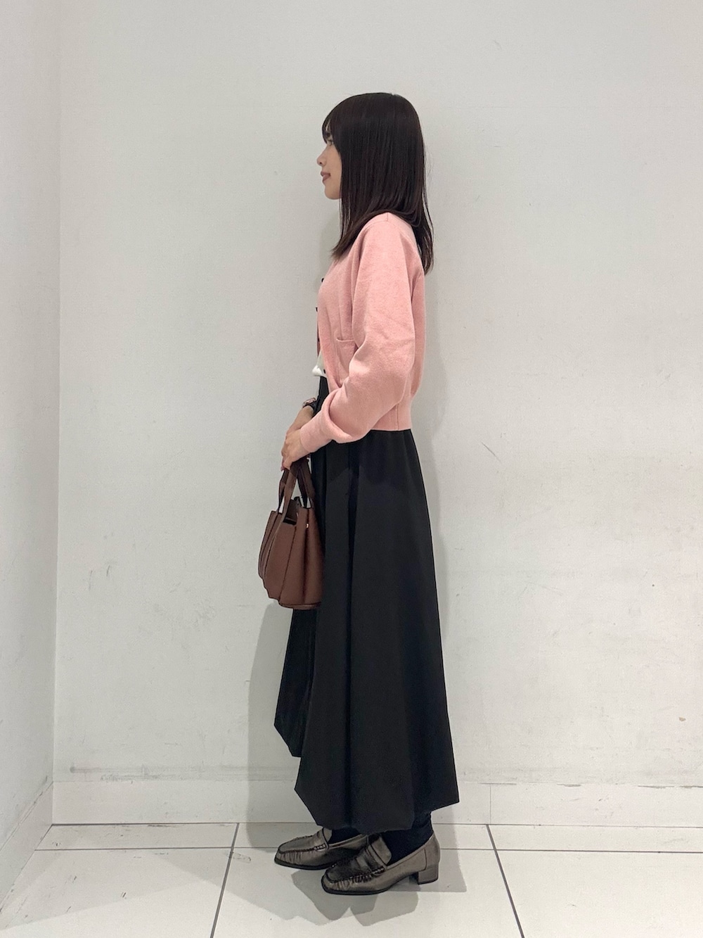 ピンク系のカーディガン/ボレロ、ブラック系のスカート、その他のローファーを着用したレディースの秋コーディネートの2枚目の写真