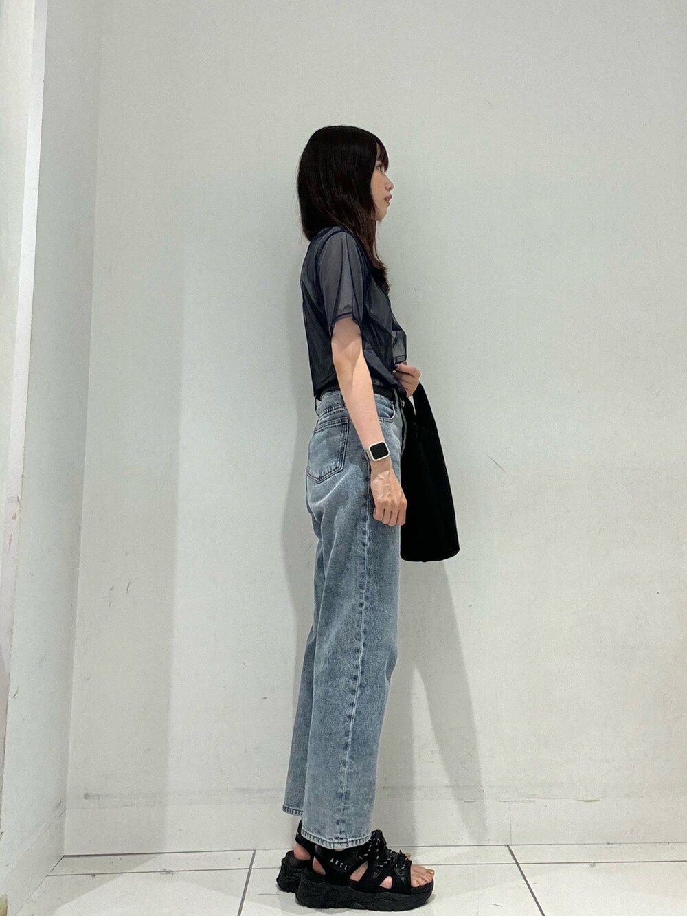 ブルー系のTシャツ/カットソー、ブルー系のデニムパンツ、ブラック系のトートバッグを着用したレディースの夏コーディネートの4枚目の写真