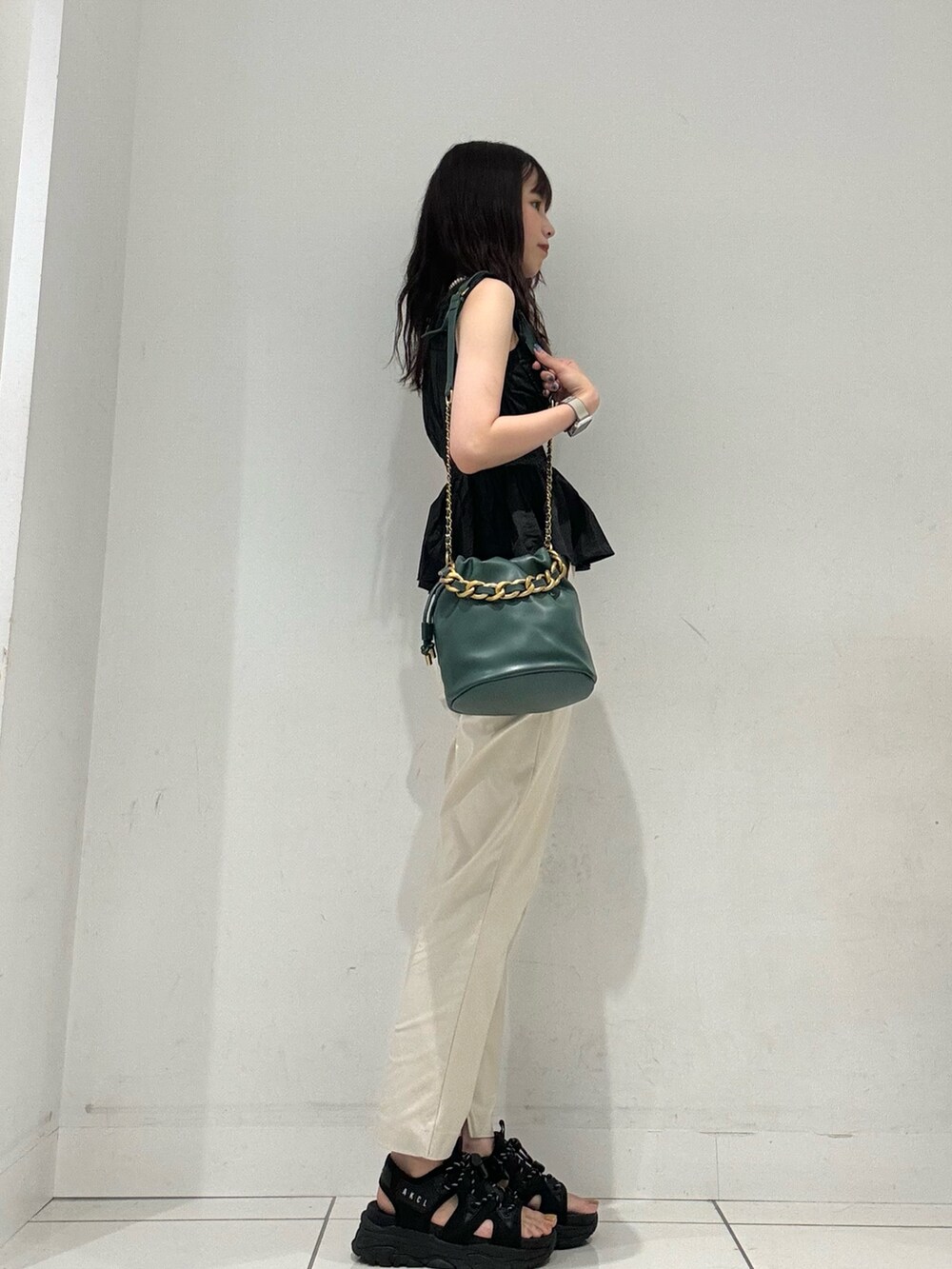 ベージュ系のその他パンツ、ブラック系のキャミソール、グリーン系のショルダーバッグを着用したレディースの夏コーディネートの3枚目の写真