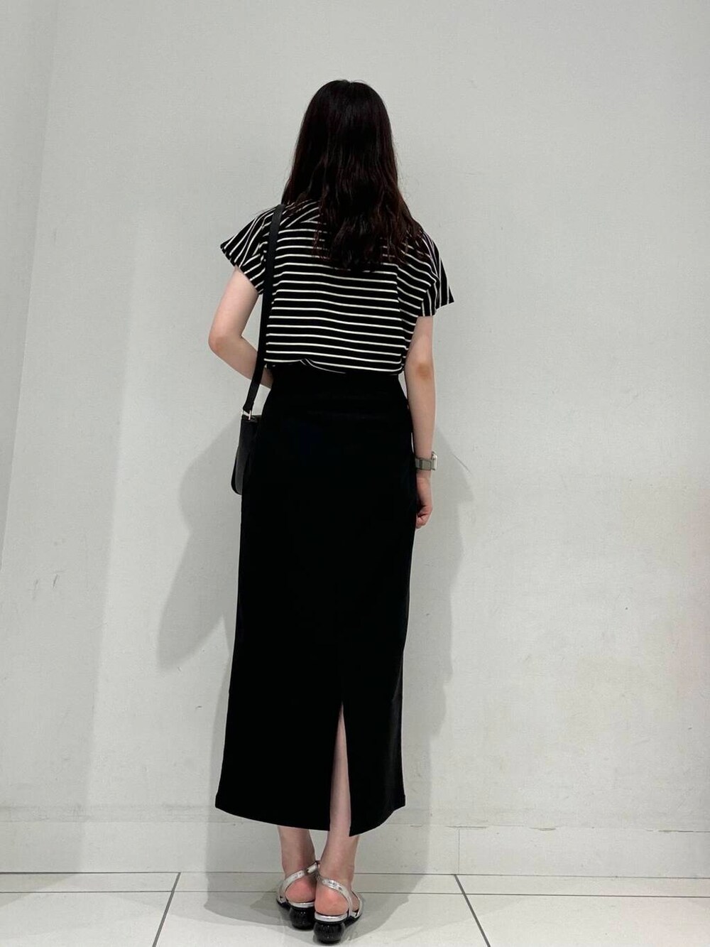 ブラック系のショルダーバッグ、ブラック系のスカート、シルバー系のその他シューズを着用したレディースの夏コーディネートの3枚目の写真