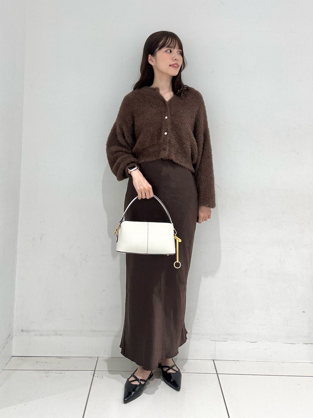 ブラウン系のスカート、ブラウン系のカーディガン/ボレロ、ブラック系のその他シューズを着用したレディースの秋コーディネートの4枚目の写真