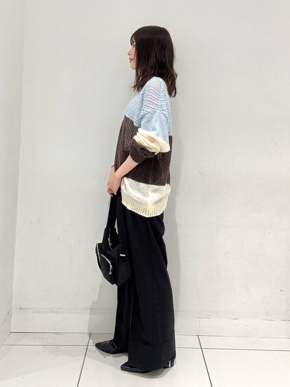 ブルー系のニット/セーター、ブラック系のその他パンツ、ブラック系のその他シューズを着用したレディースの秋コーディネートの2枚目の写真