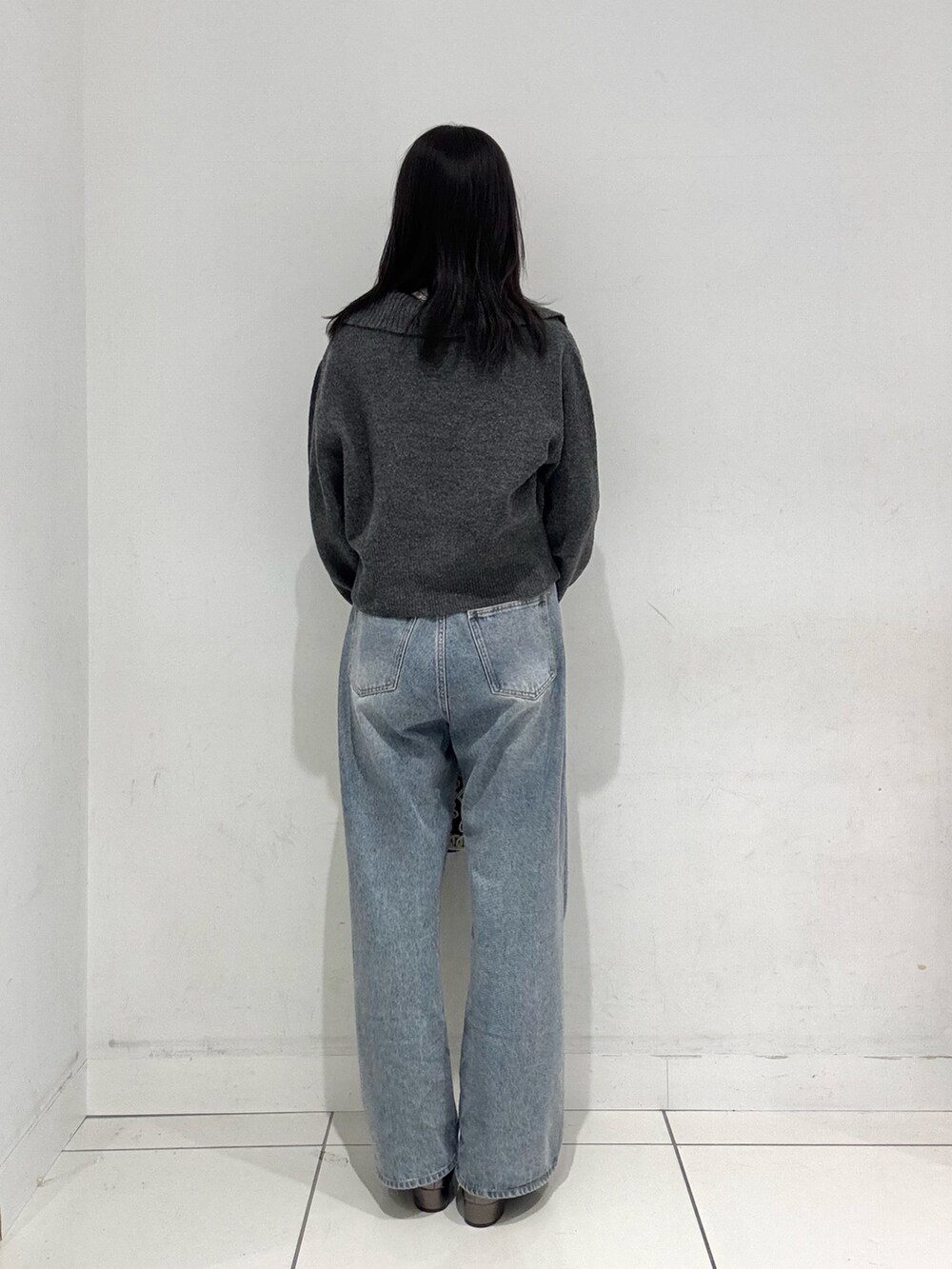 グレー系のニット/セーター、ホワイト系のニット/セーター、ブルー系のデニムパンツを着用したレディースの秋コーディネートの3枚目の写真