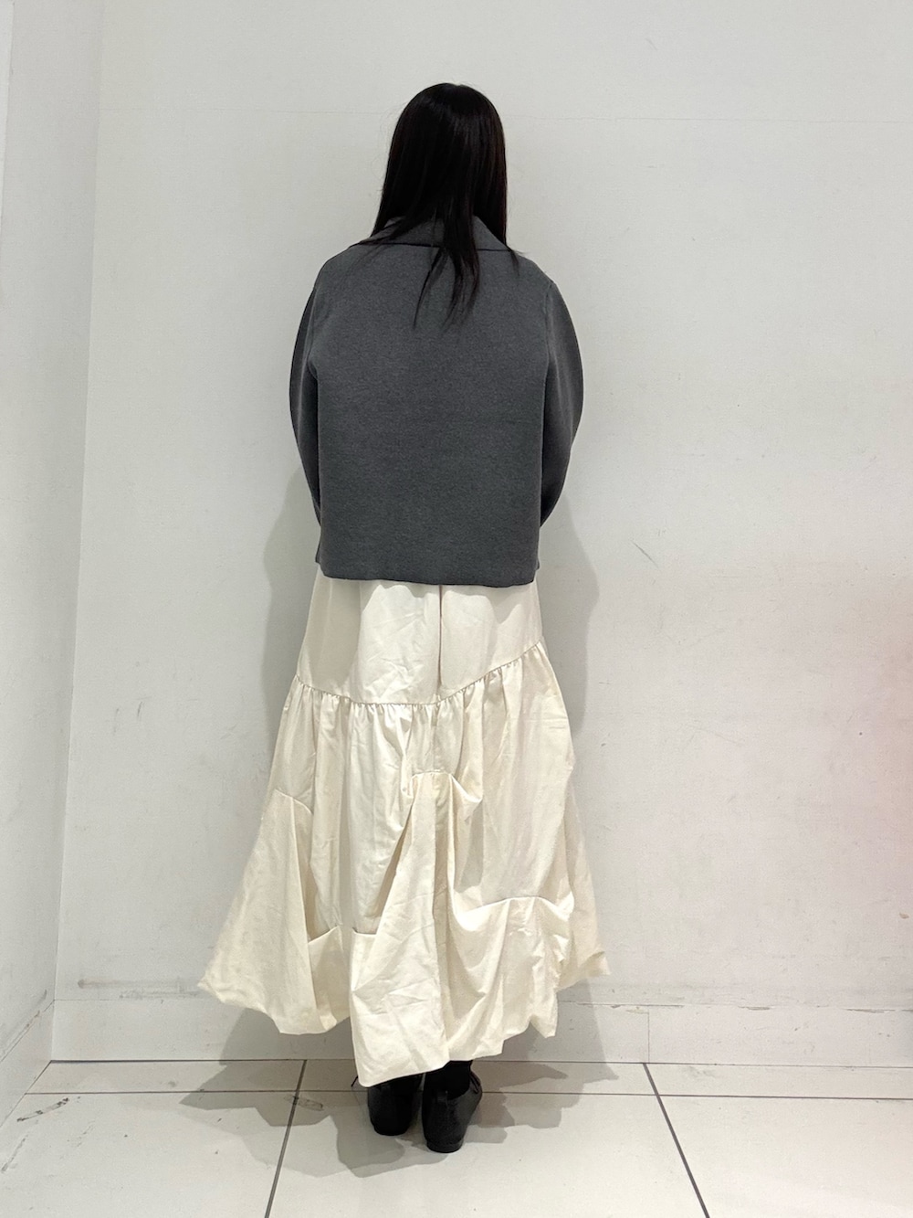 ホワイト系のスカート、ブラック系のその他シューズ、ブラック系のハンドバッグを着用したレディースの冬コーディネートの3枚目の写真