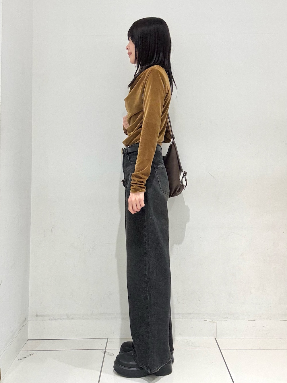 イエロー系のその他トップス、ブラック系のデニムパンツ、ブラウン系のバックパック/リュックを着用したレディースの冬コーディネートの2枚目の写真