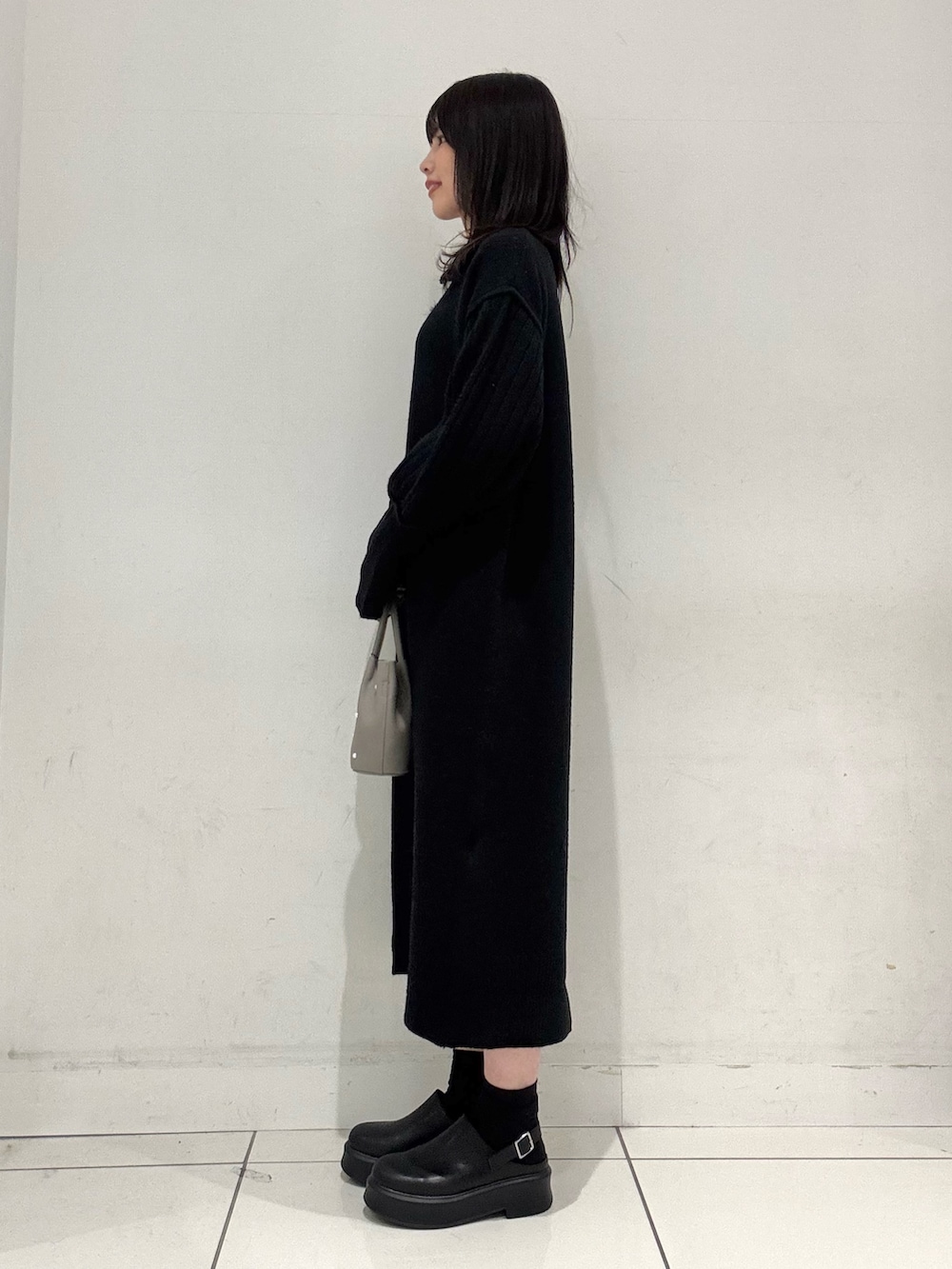 ブラック系のワンピース、グレー系のハンドバッグ、ブラック系のその他シューズを着用したレディースの冬コーディネートの2枚目の写真