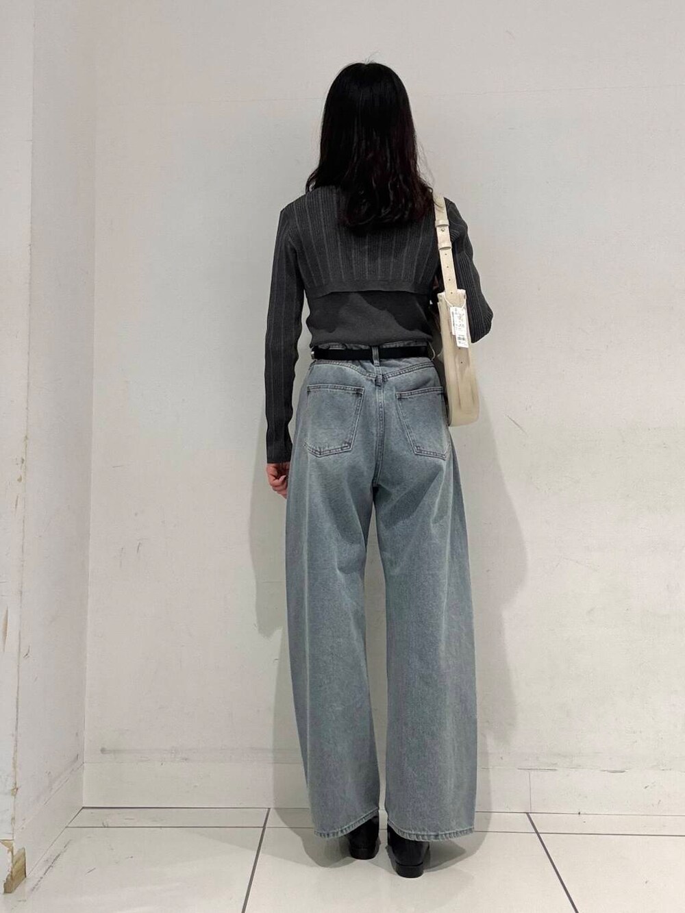 ブラック系のローファー、ベージュ系のショルダーバッグ、ブルー系のデニムパンツを着用したレディースの冬コーディネートの3枚目の写真
