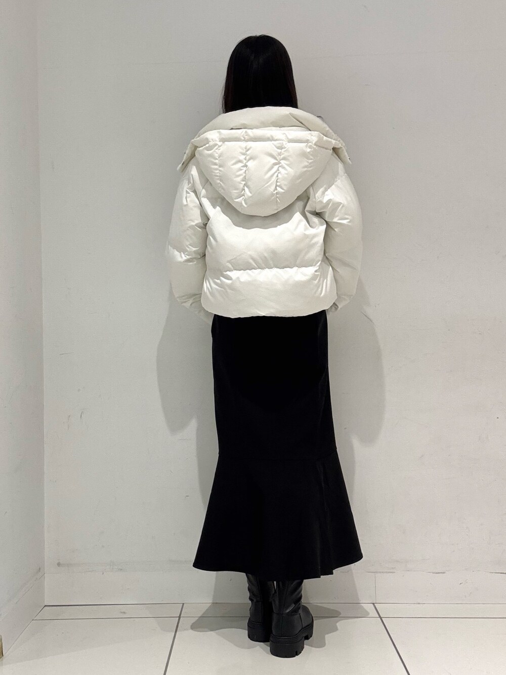 グレー系のニット/セーター、ホワイト系のダウンジャケット/コート、ブラック系のハンドバッグを着用したレディースの冬コーディネートの3枚目の写真