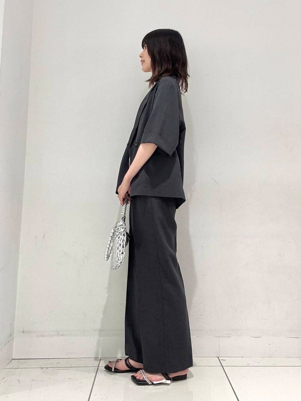 シルバー系のハンドバッグ、グレー系のその他パンツ、グレー系のその他アウターを着用したレディースの夏コーディネートの2枚目の写真