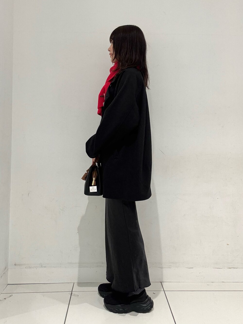 ブラック系のローファー、ブラック系のその他アウター、ブラック系のスカートを着用したレディースの秋コーディネートの2枚目の写真