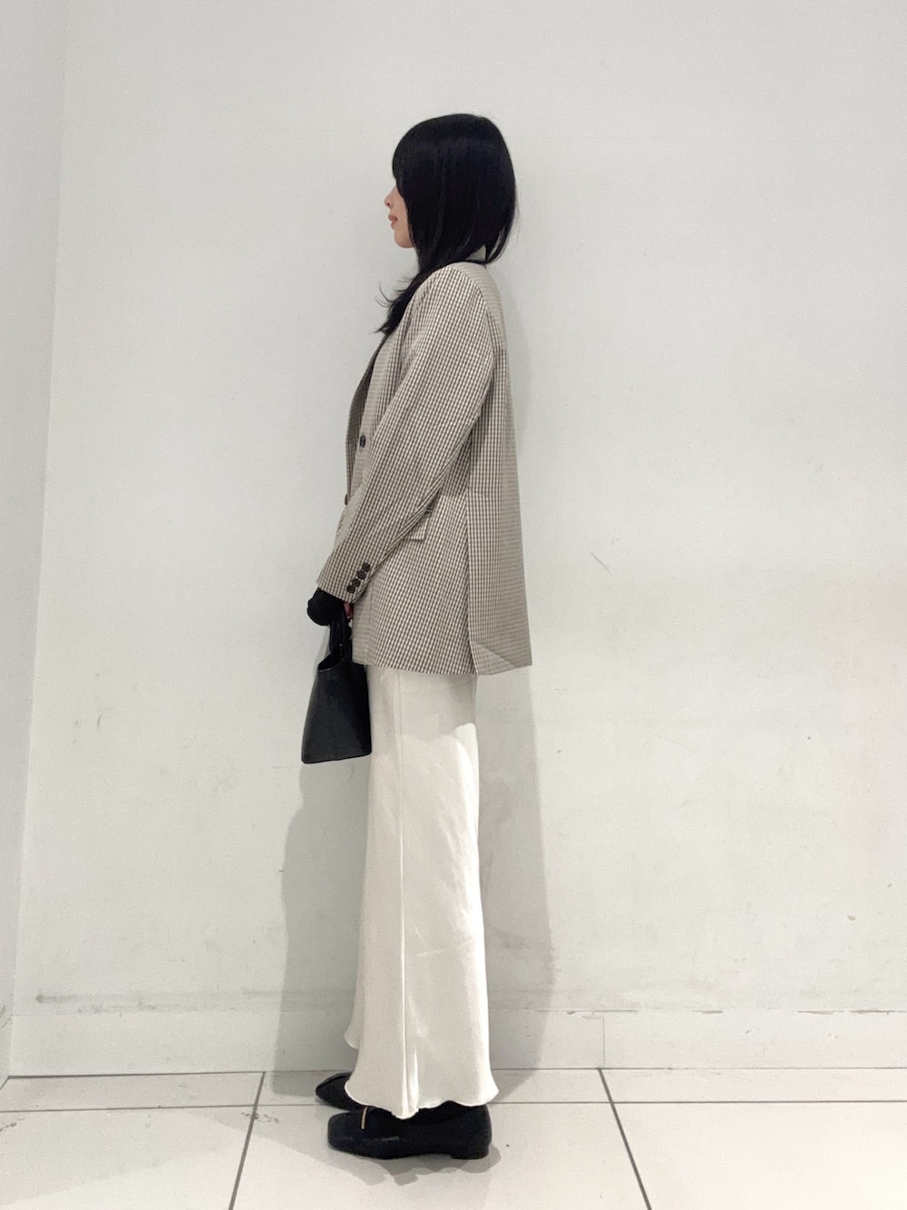 ブラック系のTシャツ/カットソー、ベージュ系のテーラードジャケット、ブラック系のその他シューズを着用したレディースの春コーディネートの2枚目の写真