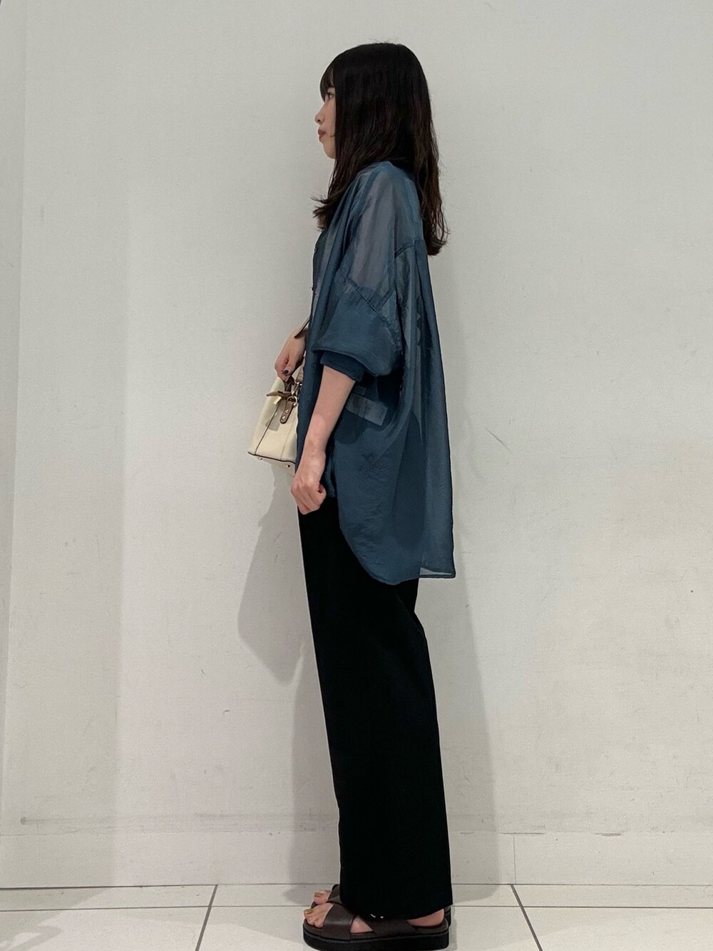 ブラック系のその他パンツ、ブラウン系のサンダル、ホワイト系のハンドバッグを着用したレディースの夏コーディネートの3枚目の写真