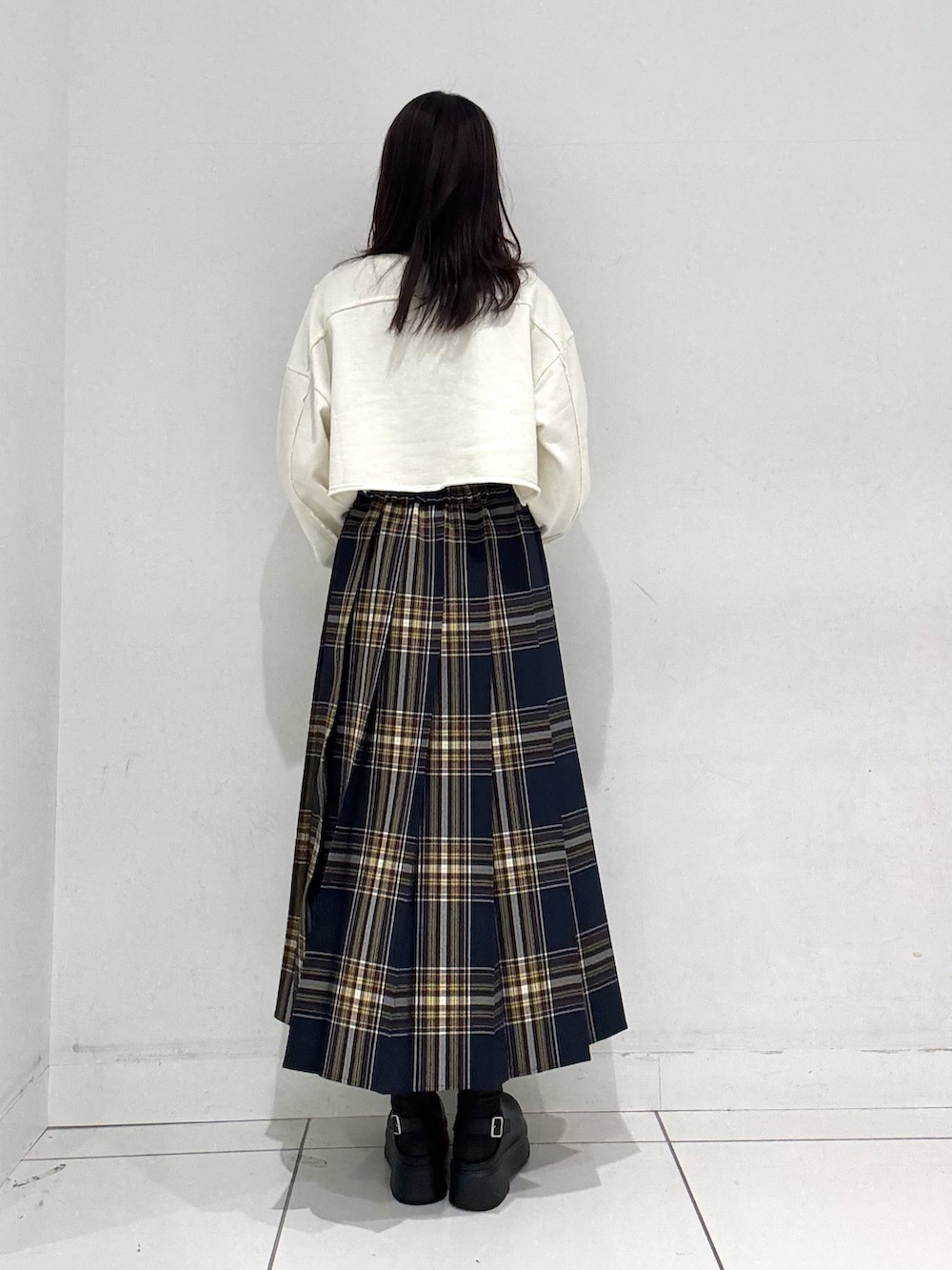 ホワイト系のスウェット、ブルー系のスカート、ブラック系のその他シューズを着用したレディースの冬コーディネートの3枚目の写真