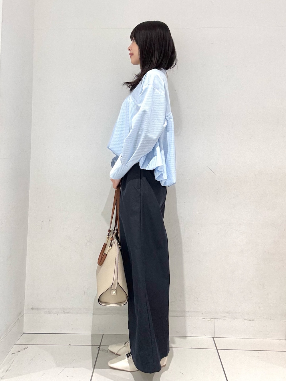 ブルー系のシャツ/ブラウス、ブルー系のチノパンツ、ホワイト系のその他シューズを着用したレディースの冬コーディネートの2枚目の写真