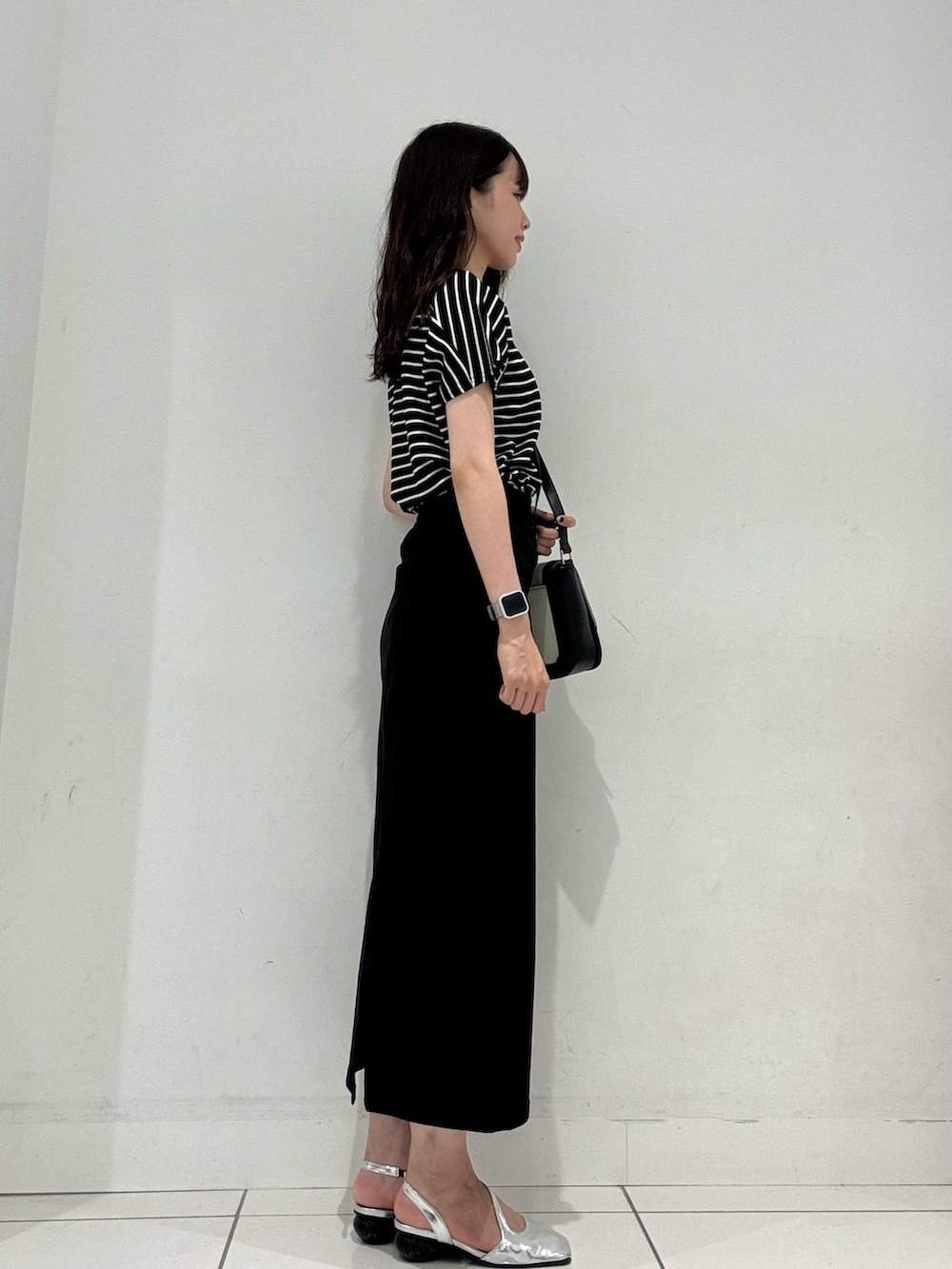 ブラック系のTシャツ/カットソー、ブラック系のショルダーバッグ、ブラック系のスカートを着用したレディースの夏コーディネートの2枚目の写真