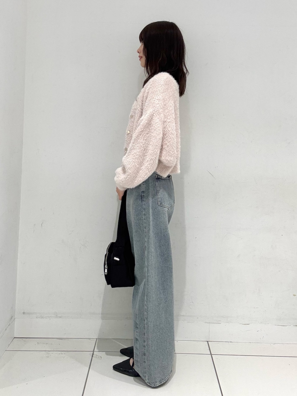 ピンク系のカーディガン/ボレロ、ブルー系のデニムパンツ、ブラック系のその他シューズを着用したレディースの秋コーディネートの2枚目の写真