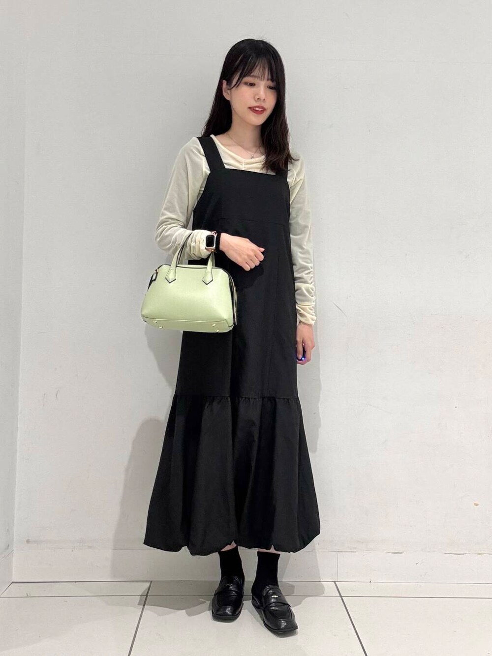 ブラック系のローファー、ベージュ系のTシャツ/カットソー、グリーン系のトートバッグを着用したレディースの春コーディネートの4枚目の写真