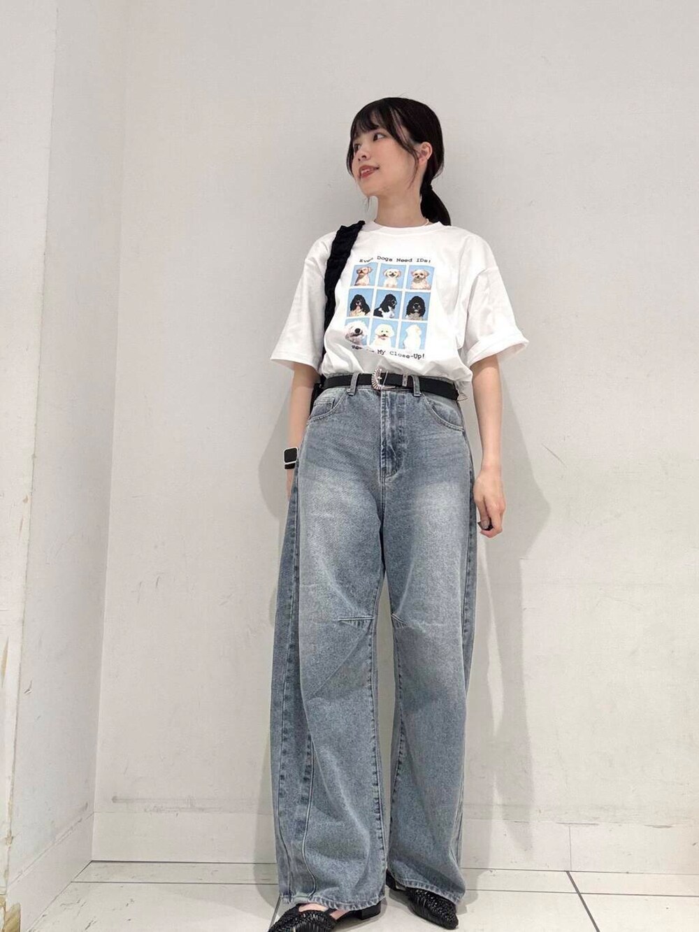 ブラック系のショルダーバッグ、ブラック系のサンダル、ブルー系のデニムパンツを着用したレディースの春コーディネートの4枚目の写真