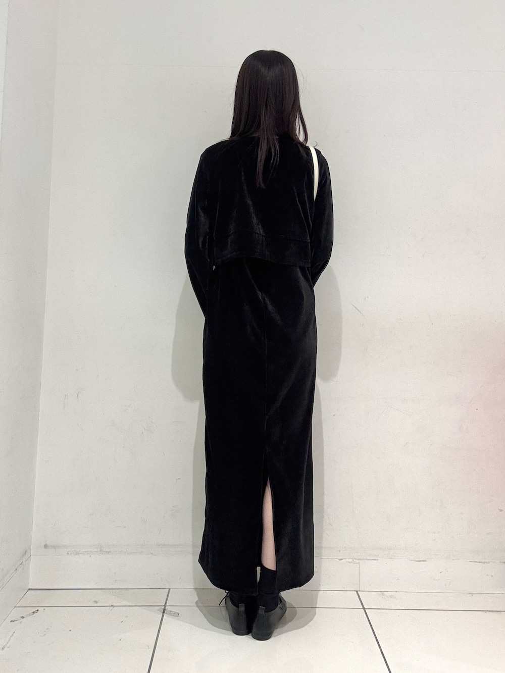 ブラック系のワンピース、ブラック系のその他シューズ、ホワイト系のショルダーバッグを着用したレディースの冬コーディネートの3枚目の写真