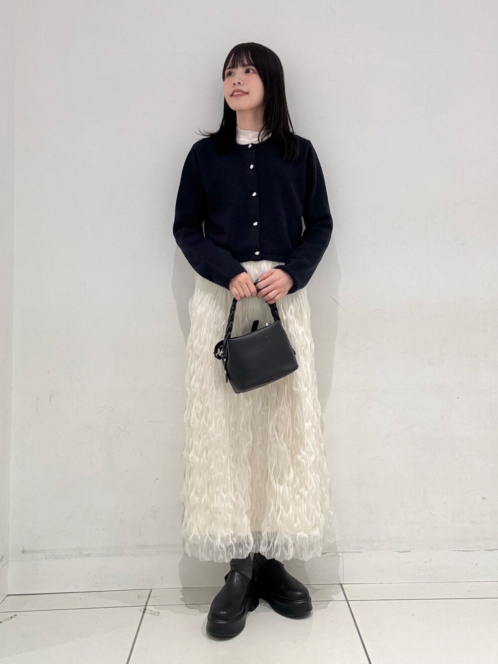 ブルー系のカーディガン/ボレロ、ホワイト系のTシャツ/カットソー、ホワイト系のスカートを着用したレディースの冬コーディネートの4枚目の写真