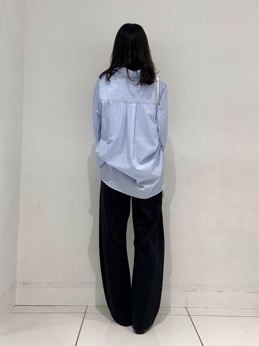 ブラック系のバレエシューズ、シルバー系のボストンバッグ、ブルー系のシャツ/ブラウスを着用したレディースの冬コーディネートの3枚目の写真